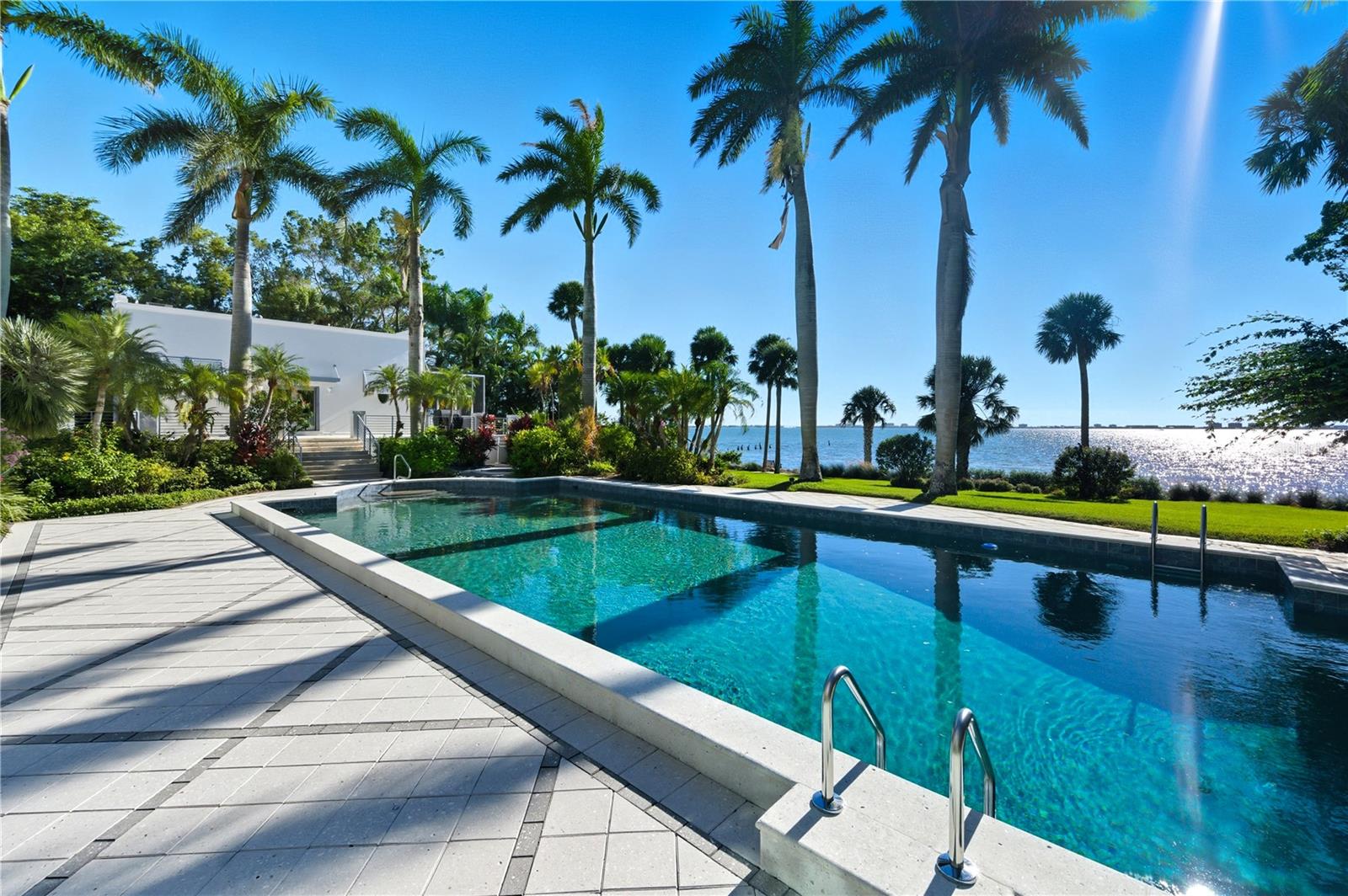 Set on 2.4 gated acres with an impressive 240 feet of pristine waterfront, this rare Sarasota compound offers over 10,000 square feet of pure privacy, serenity, and elevated coastal living. Perfectly positioned in the heart of the city yet worlds away, this estate delivers unobstructed, panoramic views of Sarasota Bay from nearly every room.

Designed for both grand entertaining and intimate living, the residence welcomes you with a double-height foyer, cascading natural light, and a sense of scale that is both dramatic and warm. Across sixteen thoughtfully curated rooms, floor-to-ceiling windows frame endless water vistas, bringing the outdoors in and creating an atmosphere of true waterfront elegance.

The estate features five spacious bedrooms and nine beautifully appointed bathrooms, including a breathtaking owners’ suite, a private, calming retreat with sweeping bay views, a spa-inspired bath, and a luxe outdoor shower surrounded by lush privacy landscaping.

For those who value lifestyle and amenities, this property offers it all:

A private tennis court tucked away behind mature tropical landscaping

A well-appointed guest house ideal for extended stays

A dedicated pool house for effortless entertaining

A four-car garage for collectors and hobbyists

Expansive terraces and outdoor lounging areas that overlook Sarasota’s most dramatic sunsets