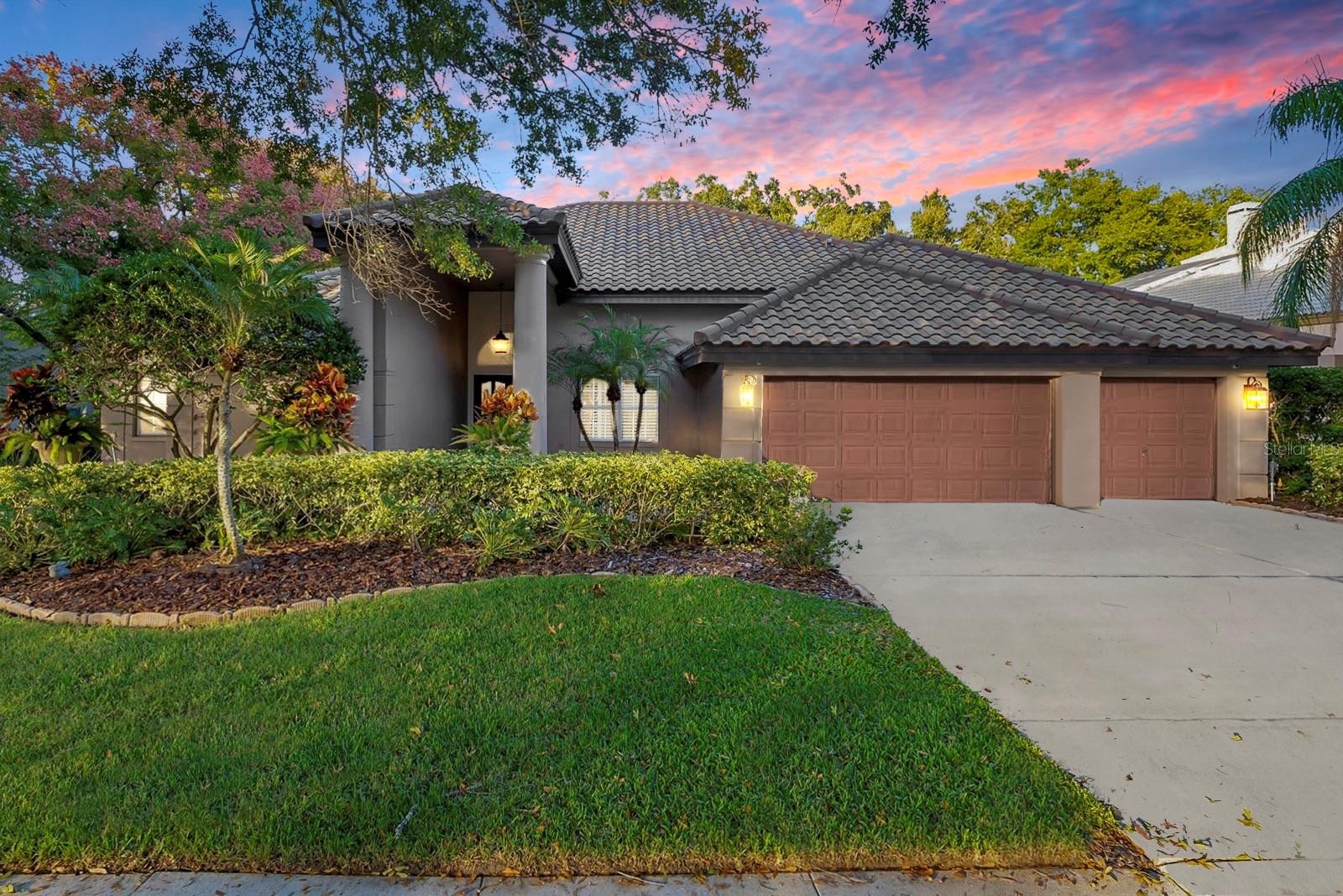Style & sophistication abound in this executive style home located within the sought after community of Cobb's Landing! This immaculately UPDATED residence is a true gem, offering a 3-way split floor plan that encompasses 4 generously sized bedrooms, 3 pristine bathrooms, and an attached 3-car garage. With over 3,100 square feet of impeccably designed living space, this home exudes elegance and comfort at every turn. As you approach the property, you'll be captivated by its gorgeous curb appeal, enhanced by a walkway of elegant pavers leading to a covered entryway adorned with double leaded glass doors. Step inside, and you'll be greeted by a foyer that opens up to a formal living room and dining room with luxurious crown and base moldings, complemented by timeless plantation shutters. Direct views of the resort-like pool area completes the welcoming experience. The home is graced with the warmth and beauty of Brazilian cherry hardwood floors throughout. The heart of this home is the updated Chef's Kitchen, which boasts high-end wood cabinetry with under and over cabinet lighting, exquisite granite countertops, stainless steel appliances, a chef's dual-fuel gas range with an electric oven, a convenient island with a breakfast bar, and a spacious eating nook that overlooks the serene views of the pool-side oasis. Open to the kitchen is the inviting family room and bar area, complete with a wood-burning fireplace and custom built-ins and plantation shutters. The master suite, privately situated behind double doors, offers a tranquil retreat with pool views and ample storage closets. The spa-like master bath is a testament to luxury, featuring Carrara marble, dual sinks, rich espresso cabinetry, and a spacious resort-style walk-in shower. The DREAM walk-in closet with organizers is both functional and elegant. Three additional well-appointed bedrooms await, including adjoining remodeled baths. The fully remodeled laundry room is amazing, with custom cabinetry, and storage galore! This leads to your 3-car garage with plenty of space to store your cars and much more including a 240v hookup for your EV. The outdoor space is a true paradise, with a built-in outdoor kitchen area just off the family room and kitchen sliders, making outdoor entertaining and living a sheer delight. Relax in the ample covered space while taking in the tropical pool area, complete with a sparkling Pebble Tec resurfaced self-cleaning saltwater pool and a heated spa with stunning stone waterfall features. The backyard offers room for your own garden, shaded by magnificent oak trees, and graced by a perennial butterfly garden. The home features a newer tile roof installed in 2015, A/C systems from 2021/2012, and a gas tankless water heater from 2019, and a freshly painted interior (2023)!  Cobb's Landing, your exclusive community, offers an array of amenities, including a community park, marina, tennis courts, and a playground nestled beneath grand oak trees with serene views of Lake Tarpon. Zoned for Palm Harbor University High School, this home truly leaves nothing to be desired. Cobb's Landing is strategically located, providing easy access to "A" Rated Schools, pristine beaches such as Honeymoon and Caladesi Island, numerous golf courses, county parks, the Pinellas Trail, shopping, restaurants, and just a short 25-minute drive to Tampa International Airport.  Discover more details in the Featured Sheet – this property is a must-see masterpiece!