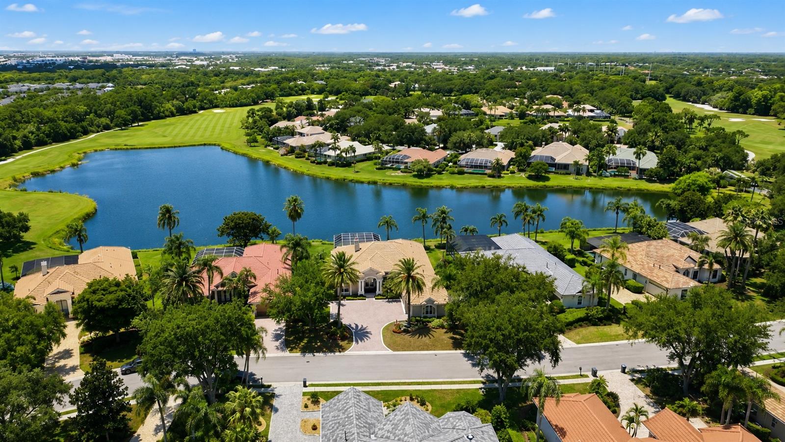 Welcome to University Park Country Club, where luxury living meets breathtaking views. This exceptional custom-built residence by renowned builder Dan Najjar designed to exceed every expectation.
From the moment you step through the front door, you are greeted by spectacular panoramic views of the lake and golf course, creating a stunning backdrop for everyday living. The thoughtfully designed open-concept floor plan features soaring ceilings, expansive living spaces, and seamless indoor-outdoor flow, maximizing both comfort and elegance.
Every detail of this home reflects superior craftsmanship and quality, from the high-end finishes and architectural details to the carefully planned layout that perfectly balances sophistication and functionality. Built with uncompromising attention to detail, this residence showcases timeless design and enduring value.
Whether entertaining guests or enjoying a quiet evening overlooking the water, this home offers an unparalleled lifestyle in one of Sarasota's most sought-after communities. This is luxury living at its finest.
EXPERIENCE The University Park With its mature landscape and sprawling natural beauty, University Park is the premier master-planned community in the Sarasota area. Behind the secured, staffed entrance is an award-winning, resident-owned community featuring 27 holes of four-star rated golf, eleven lighted Har-Tu tennis courts, four pickleball courts, a fitness center, croquet, miles of tree-lined streets for walking or biking, and first-class dining. Also offered are numerous social activities and many social clubs designed to fit a variety of interests. Located only four miles from downtown Sarasota and its spirited arts community, museums, shopping, dining, and first-class healthcare, University Park is an oasis from the City but close enough to all amenities. It's only a short 15-minute drive to some of America's finest beaches, superb outdoor recreation areas, including the internationally renowned Nathan Benderson Park, the famed Ringling Museum, various boating options, and the acclaimed St. Armands Circle. University Park's breathtaking beauty is unmatched by any other. Designed with comfort and privacy in mind, this split-bedroom floor plan offers a luxurious primary suite on one side of the home, while two additional bedrooms, a private office, and a media room are thoughtfully situated on the opposite wing. The expansive outdoor living area is destined to become your private retreat for relaxation and entertainment, complete with generous covered spaces surrounding the spectacular pool and spa. RECENT UPDATES: POOL CAGE 2025, ROOF 2024, AC 2021