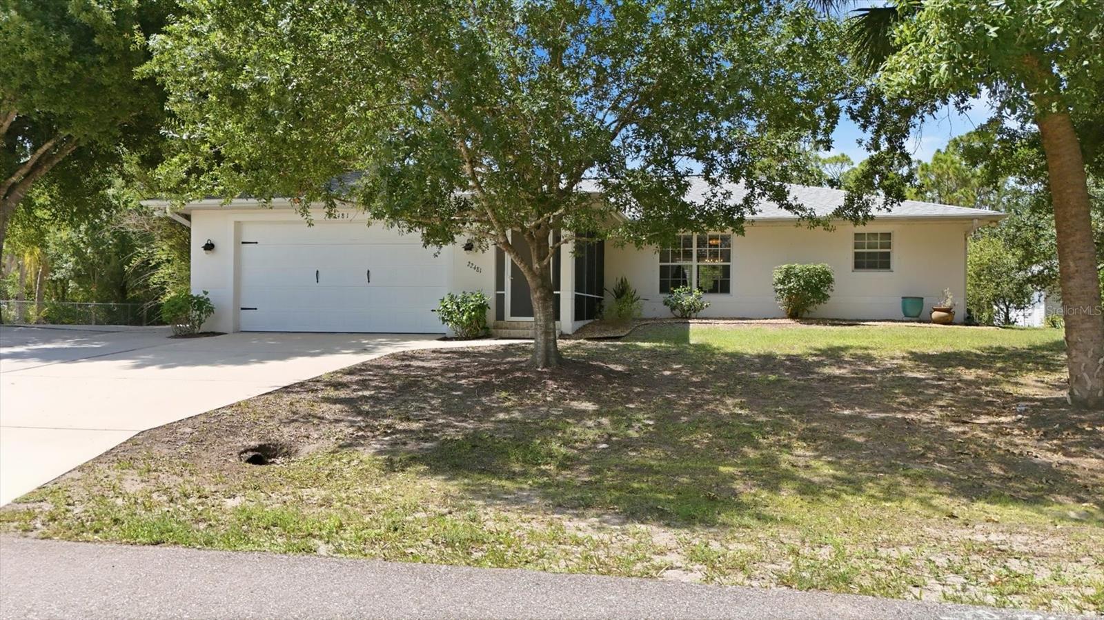 Beautifully maintained 3 bedroom, 2 bathroom, 2 car garage home with 1,627 sq ft under air, built in 2003 and set on an impressive 0.46 acre double lot offering privacy, space, and a peaceful wooded backdrop.
This property includes rare extras such as a dedicated RV pad with 220 hookup and a 20' x 20' outbuilding with electric—ideal for a workshop, storage, or hobby space.
Inside, the home features a bright, open layout with a vaulted 10' ceiling in the main living area. The spacious kitchen is a standout, offering extensive counter space, abundant cabinetry, a breakfast bar, and a pantry closet—perfect for cooking, entertaining, or everyday convenience.
A signature feature of this home is the seamless indoor outdoor connection: the primary bedroom, guest bedroom, and dining area each have two panel sliding glass doors that fully pocket open, creating wide, unobstructed access to the expansive outdoor living space. The large covered and tiled lanai extends to a paver patio within a screened enclosure, overlooking a lovely garden setting with a swing.
The primary suite offers generous space, a walk in closet, and an ensuite bath. Two guest bedrooms are located on the opposite side of the home with a full bath and a pocket door for added privacy—ideal for guests or multigenerational living.
Additional highlights include: • Newer roof and A/C • Well and septic with water softener system • Quiet, private setting on nearly half an acre.
Centrally located in Port Charlotte, offering quick access to restaurants, shopping, medical facilities, and I 75, as well as convenient connections to Punta Gorda and North Port.
A rare combination of privacy, storage, indoor outdoor living, and thoughtful design—this home delivers exceptional value and a true Florida lifestyle.