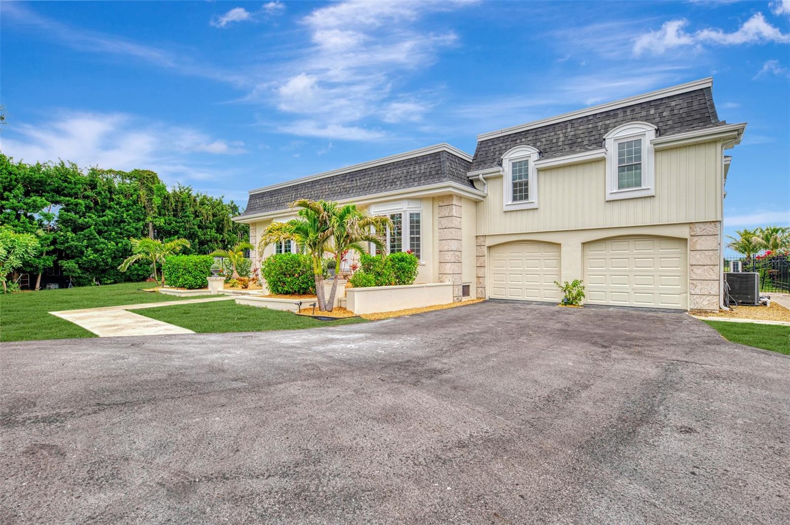A rare opportunity to own one of the most distinctive homes overlooking Bradenton Country Club. Originally designed by renowned Tampa architect Harry MacEwen, this custom residence combines timeless architectural character with extensive modern upgrades and some of the most spectacular water and golf course views in the community. Designed to capture the scenery from nearly every room, the home features soaring volume ceilings, bay windows, wood flooring throughout much of the living space, a wood-burning fireplace, exposed beams, custom built-ins, abundant storage, and an inviting floor plan ideal for both everyday living and entertaining.
The heart of the home is a completely renovated chef's kitchen featuring dual ovens, dual dishwashers, a premium induction cooktop, and sweeping views of the pool, water, and golf course beyond. The spacious primary suite includes a beautifully remodeled bath, while the flexible second-floor layout offers additional bedrooms and living space ideal for guests, recreation, or work-from-home needs.
Outdoor living is equally impressive. An infinity-edge pool overlooks the tranquil water and fairways, complemented by an expansive travertine deck with multiple areas for dining, lounging, and entertaining. Aluminum and privacy fencing provide both security and seclusion.  The current owners have invested extensively in the property, including replacing the roof, impact-rated sliders and windows, major kitchen and bath renovations, HVAC replacement, siding replacement, updated irrigation, refreshed interior and exterior paint, upgraded bathrooms, and a redesigned circular driveway.  With its unique architectural pedigree, breathtaking views, and extensive list of recent improvements, this home offers a rare combination of character, comfort, and peace of mind in one of Bradenton's most desirable golf course settings.
Room Sizes are approximate and should be verified by the buyer.