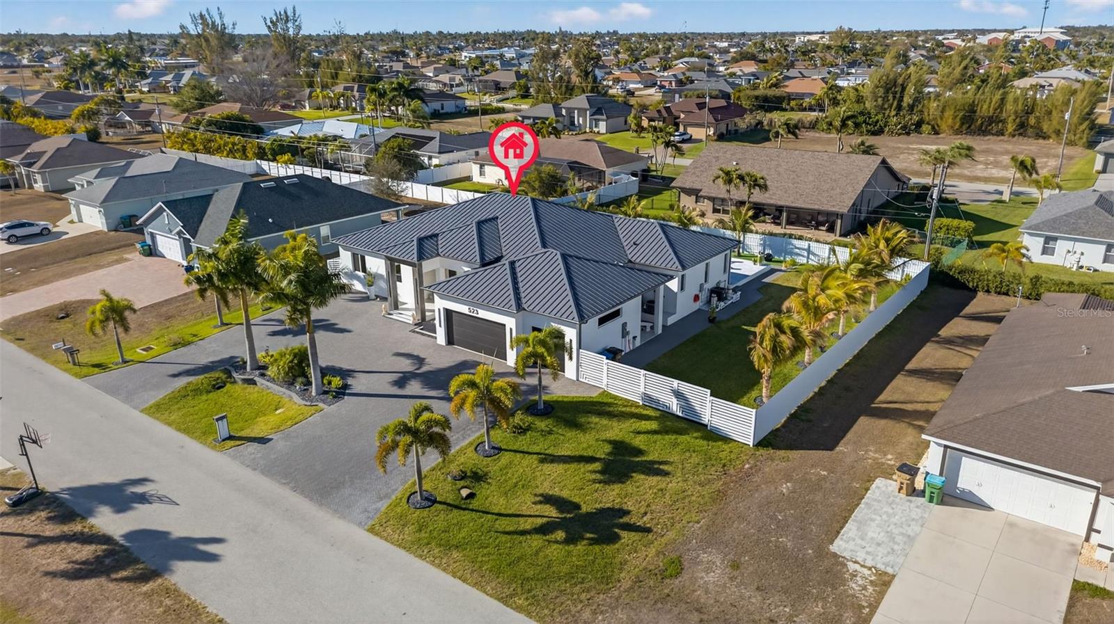 WELCOME to this STUNNING & MODERN 2024 Built Home offering the perfect blend of luxury, comfort, and functionality in SW Cape Coral, FL. What sets this home apart from all others is the open layout from the living area to the kitchen area that offers more room and privacy. This expansive home features 4 spacious bedrooms plus a private office, with two of the bedrooms designed as private en-suite retreats—ideal for guests or multi-generational living. 

With 3.5 beautifully appointed bathrooms and a 3-car garage, this home provides the space and flexibility today’s lifestyle demands with living space just under 3,000 sq.ft. A Sleek metal roof and a large circle driveway with pavers and a welcoming water fountain upon entry. Step inside and experience 13 ft. soaring ceilings, abundant natural light, and sleek contemporary finishes throughout. Large porcelain tile throughout the entire house with elegance in every corner. 

The heart of the home is the large and uniquely designed kitchen with a large kitchen island and beautiful glossy cabinets, built in microwave and stove and high-end kitchen appliances to complement the home entirely. With plenty of counter space the kitchen also features a coffee station with additional storage, located across from the laundry room. Don’t forget the large walk-in pantry! Designed for seamless indoor-outdoor living, the backyard is your private resort, situated on an oversized (triple-lot) and fully fenced in with palms galore. Enjoy the large heated -saltwater pool year around along with a fully equipped summer kitchen, perfect for hosting gatherings or relaxing in true Florida style. This home also offers impressive upgrades focused on both luxury and protection, including a built-in Sonos audio system throughout the entire home for immersive sound in every room, electric hurricane shutters in the lanai rated to withstand up to 165 MPH winds, and electric blinds and window coverings throughout for convenience, privacy, and modern elegance. 

As an added bonus, the furniture is not included but negotiable with the sale, offering a potential turnkey opportunity for buyers seeking a seamless move-in experience. This residence combines modern sophistication, smart features, storm protection, and resort-style outdoor living—truly a home designed for those who expect exceptional quality and comfort. Schedule a showing today to see it for yourself!