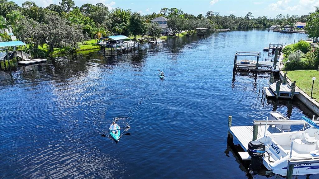 Experience the pinnacle of Florida waterfront living with Gulf of America access via the Anclote River! This exceptional estate is located in the highly sought-after, privately gated Riviera community of just 37 homes. Situated on a breathtaking 1.47-acre riverfront lot, this meticulously maintained 4-bedroom, office, 3-bath residence with an oversized 4+ car garage offers the perfect blend of luxury, privacy, and outdoor adventure, complemented by over $200,000 in recent upgrades and improvements. Major updates include: 2024 roof and water heater; 2023 water softener; 2022 granite kitchen countertops, sink, dishwasher, microwave, and septic tanks; 2021 pool resurfacing, new pavers, generator hookup, irrigation system refresh, exterior lighting, and exterior paint; 2019 remodeled secondary bathrooms and pool/spa heater; and 2017 flooring throughout most of the home. Nestled at the end of a quiet cul-de-sac and surrounded by lush landscaping, this stunning property welcomes you with impressive curb appeal and a serene setting. Inside, an inviting open floor plan showcases wood-look tile flooring throughout, elegant arched passageways, tray ceilings, and seamless indoor-outdoor living. The formal living and dining rooms provide the perfect backdrop for entertaining, while French doors open to the spectacular pool and waterfront views beyond. At the heart of the home is the upgraded chef’s kitchen featuring wood cabinetry, granite countertops, breakfast bar seating, a cozy breakfast nook, double ovens, cooktop, tile backsplash, and abundant workspace for gatherings large and small. The spacious family room offers a comfortable place to relax while enjoying beautiful views of the outdoor living areas. The luxurious primary suite serves as a private retreat, complete with tray ceilings, double walk-in closets, pool access, and tranquil views of the pond, fountain, and river. The spa-inspired ensuite bath features dual vanities, a Jacuzzi jetted tub, and an impressive pass-through double shower. Three additional bedrooms provide ample space for family and guests, while a dedicated office with French doors creates the ideal work-from-home environment. Step outside to your own private resort. The screened lanai features a pool, heated spa with cascading waterfall, expansive paver deck, a large covered outdoor living area, & pre-plumbing for an outdoor kitchen. The fenced backyard overlooks a pond and fountain before extending to the riverfront beyond. A winding boardwalk leads through a peaceful natural setting to a riverside entertainment area with firepit and a floating boat dock offering direct access to the Anclote River, the Gulf of America, world-class fishing, boating, island hopping, waterfront dining, and unforgettable Florida sunsets. Watch dolphins and manatees from your own backyard while enjoying one of the area's most desirable waterfront lifestyles. Car enthusiasts and outdoor adventurers will appreciate the massive 30x36 side-entry garage with approximately 1,080 square feet of space for vehicles, boats, jet skis, golf carts, and recreational equipment. One garage door is oversized to accommodate larger vehicles. Residents of Riviera enjoy a private community boat ramp, low HOA fees, no CDD fees, and a prime location just minutes from Tarpon Springs, waterfront restaurants, shopping, and Gulf beaches. This is a rare opportunity to own a private riverfront sanctuary where luxury, nature, and adventure coexist in perfect harmony.
