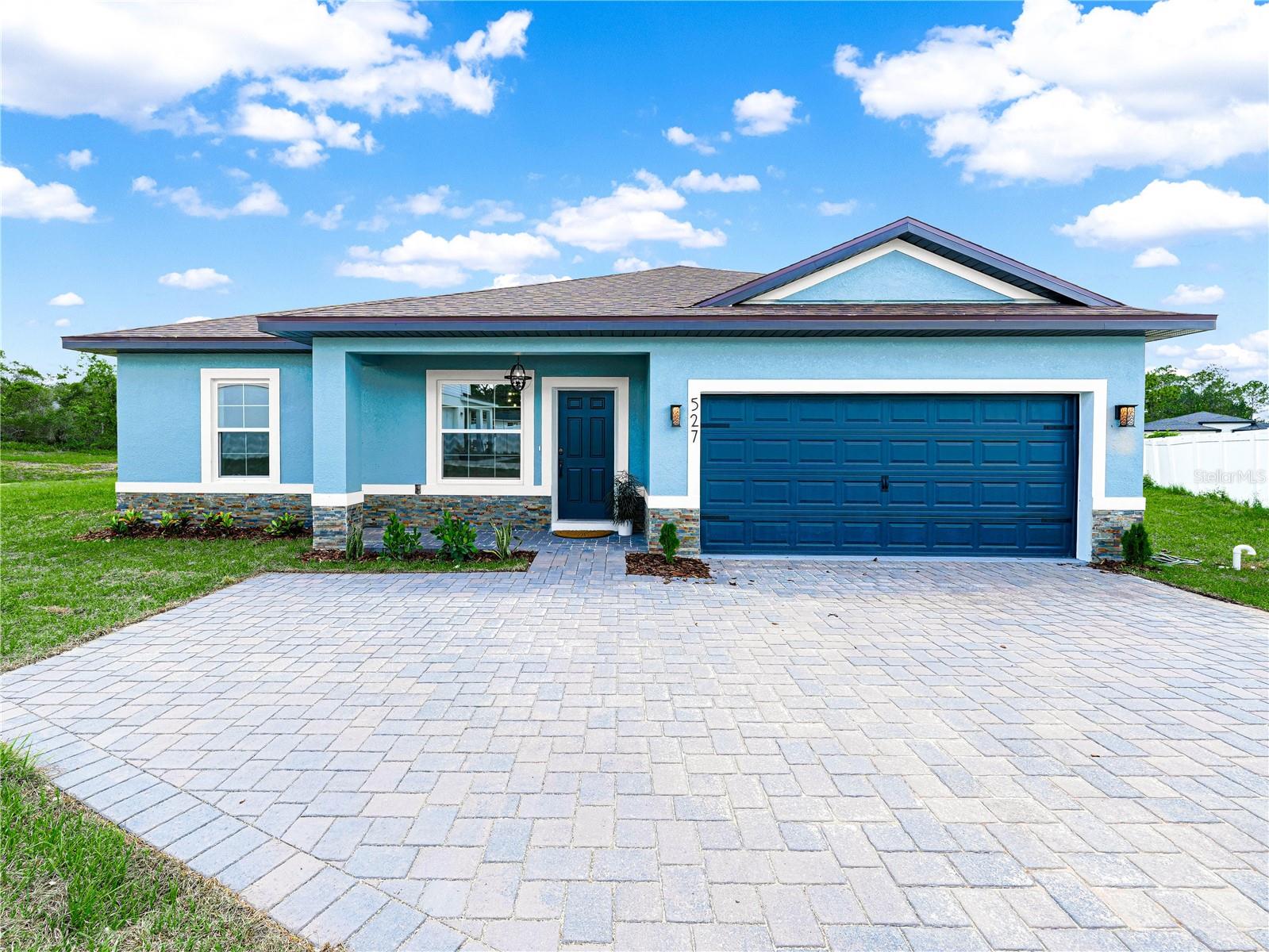 This is not your typical new build and it comes with incredible financing options! You can purchase this home with NO MONEY DOWN and ALL CLOSING COSTS COVERED, making homeownership more accessible than ever! Thoughtfully custom built and finished with intention, this home was designed for real life, not mass production. From the moment you walk in, the tall 9'4" ceilings and wide open layout make the home feel bright, welcoming, and comfortable. Luxury vinyl plank flooring flows throughout, creating a clean, modern look that instantly feels like home. The kitchen is truly the heart of the space. With quartz countertops, a marble backsplash, farmhouse sink, oversized island, and dark stainless steel appliances, it is both beautiful and highly functional. Whether you are hosting friends, cooking for family, or enjoying a quiet morning coffee, this is a kitchen you will love spending time in. The large pantry is one of those details that makes everyday life easier. The primary suite feels like a private retreat. It features an oversized walk in closet and a spa inspired bathroom with a freestanding soaking tub, a spacious glass shower, dual sinks, and elevated ceramic and natural stone finishes. The additional bedrooms are filled with natural light, including two connected by a Jack and Jill bathroom, plus a separate full bathroom that is perfect for guests. You will notice custom touches throughout the home, including stone and tile accent walls, upgraded lighting, modern dark hardware, and a spacious laundry room with extra storage and a utility sink. Outside, the curb appeal continues with a stone paved driveway and walkway, stacked stone accents and a large rear patio ready for outdoor living. The two car garage is finished with durable epoxy flooring. Beyond the design, this home was built with efficiency and peace of mind in mind. Energy saving features include double pane low E windows and doors, R30 attic insulation, LED lighting, and Energy Star appliances to help keep monthly costs lower. The home also includes an industry leading 10 year structural warranty. Located in the desirable Poinciana Villages community, residents enjoy multiple parks, an active community center, aquatic and fitness facilities, and a low HOA that even includes cable and internet. To top it all off, this home qualifies for exceptional financing options. You can purchase this home with NO MONEY DOWN and ALL COVERED CLOSING COSTS. Come take a look in person and see why this home offers the perfect balance of comfort, quality, and value! Please note that actual home may differ in finishes and colors.