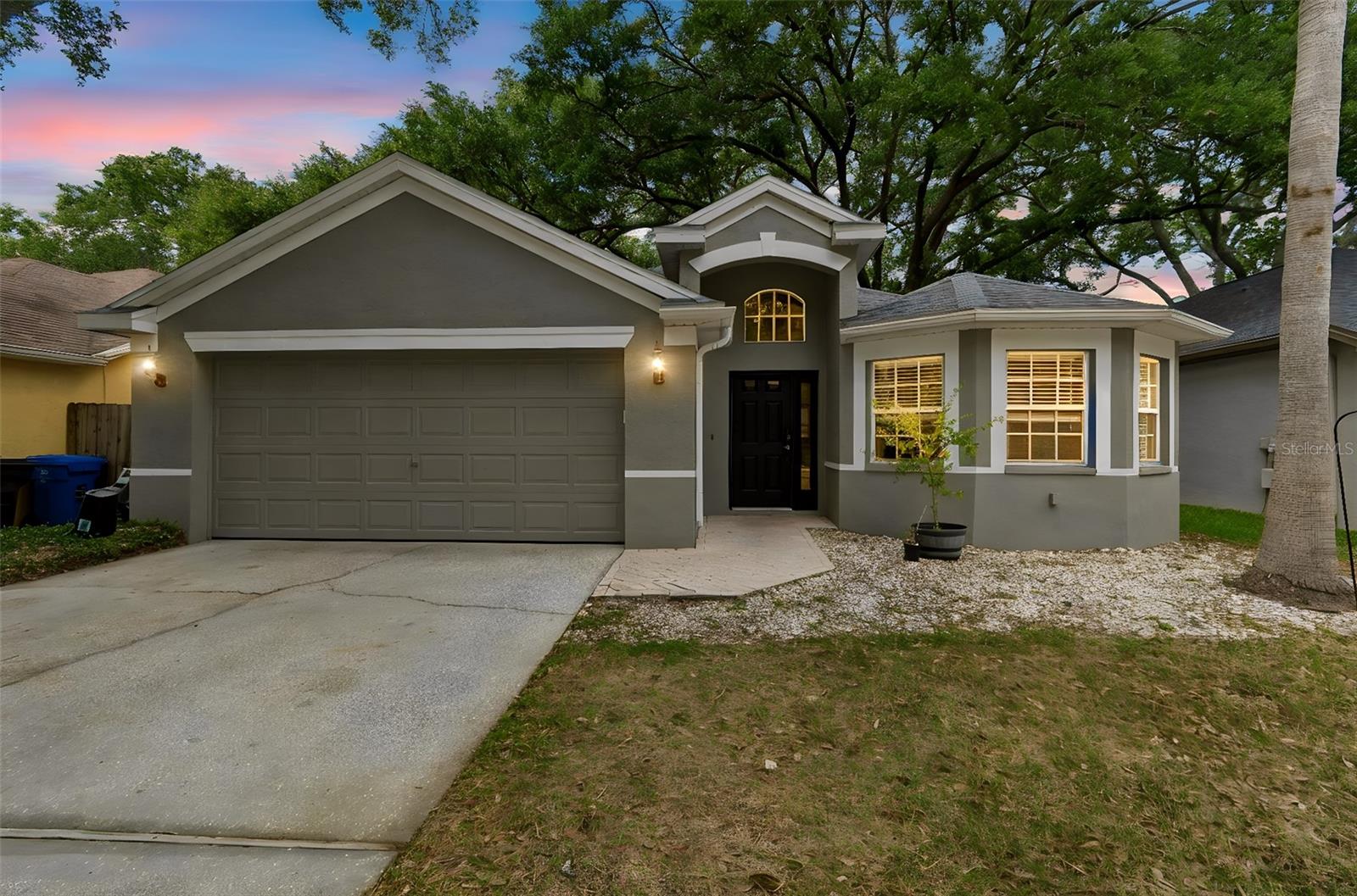 Welcome to Whispering Oaks, a gated community in the Carrollwood area of Tampa! This beautiful 3-bedroom, 2-bath, 2-car garage home features soaring vaulted ceilings, elegant arched doorways, and a welcoming foyer with decorative inlay that opens to the formal living and dining rooms, accented by columns and art niches. The kitchen is equipped with stainless steel appliances and an oversized granite countertop that opens to the family room, creating the perfect space for everyday living and entertaining. The spacious primary suite offers a walk-in closet and French doors leading to the covered, screened patio. The primary bathroom features a large walk-in shower, dual sinks, and neutral ceramic tile. Two additional bedrooms share a nearby full bathroom. Bring the outdoors in with the screened lanai featuring pavers, perfect for relaxing or entertaining. Enjoy the peace and tranquility of the beautifully landscaped backyard, complete with mature shade trees. Its prime location offers easy access to top-rated schools, shopping, dining, golf courses, county parks, beautiful beaches, and Tampa International Airport. Commuting is a breeze with convenient access to Downtown Tampa, Clearwater, and St. Petersburg.