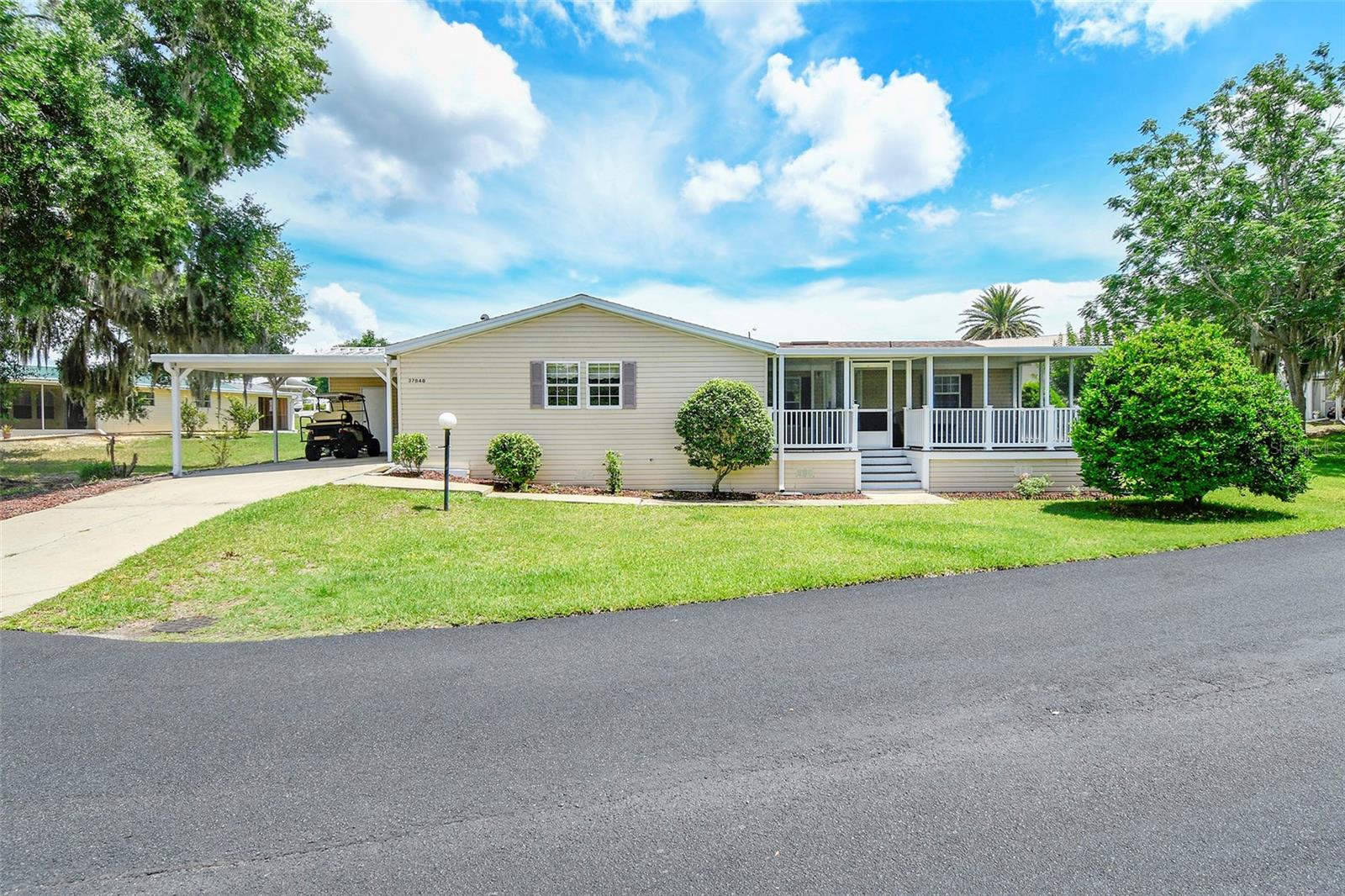 Don’t think about moving into a brand new neighborhood when you can move into this established community and get to know your neighbors very quickly at all the arranged events. This is a wonderful opportunity to buy one of the largest homes in the community at 1863 sq ft and is sitting on 2 lots. There is also an enclosed lanai to the rear and a screened lanai that overlooks the green area and trees, in the front. The rear lanai has solid screening and the front lanai has net screening.  The kitchen is a cook’s dream! Once viewed you will fall in love with this property!  Another important item to flag is that you OWN your own lot. No rent, just the HOA  payment that includes use of the clubhouse with meeting room, kitchen, library with pool table,  outdoor heated swimming pool & spa, shuffleboard court, and fishing pier with boat dock on beautiful Lake Yale. You can fish from the dock or arrange to keep your boat in a storage compound which can house trailers, boats, etc. at no charge. Also included in your HOA fee is grass cutting of both of your lots.  All the rooms have wood floors with the exception of the utility room and bathrooms, which are vinyl. If you want luxurious living, welcome to 37848 Maywood Bay Drive.