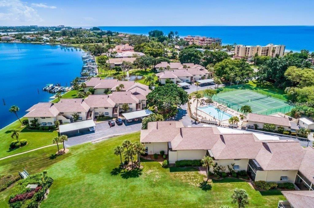 REDUCED AND INCREDIBLE VALUE!  EXCEPTIONAL FULL BAY VIEWS, PRIVATE BEACH ACCESS AND KAYAK LAUNCH, HURRICANE-RATED WINDOWS AND SLIDERS, UPDATED BATHS AND MORE!    This 2BR/2BA retreat at Pelican Harbour & Beach Club delivers the quintessential Longboat Key lifestyle. From its 2nd-floor vantage point, enjoy peaceful sunrises over the Bay and the tranquil fountain view from your screened lanai, surrounded by lush tropical landscaping. Then, end your day with spectacular Gulf sunsets and leisurely beach walks from your private beach access. The updated kitchen gleams with new 2025 solid quartz countertops, stainless Samsung appliances, a tile backsplash, and a breakfast bar island—perfect for entertaining. Open living and dining areas flow seamlessly toward the water, creating a bright, inviting space ideal for relaxing or hosting friends. The spacious owner’s suite opens to the lanai and features a 2023-renovated ensuite bath with stone countertops, dual sinks, porcelain tile flooring, a glass shower, and custom closets. The guest suite offers another beautifully updated bath and generous storage. Additional highlights in-unit laundry, 2023 roof, 2024 exterior paint, and a hurricane-rated carport conveniently located just outside your door. This unit is currently rented, and tenants will vacate or stay so you can continue to earn rental income immediately! Ideally situated mid-island, Pelican Harbour & Beach Club offers outstanding amenities: Bay and beach access, first-come dock slips, a heated resort-style pool, two newly resurfaced tennis/pickleball courts, a clubhouse with social activities, kayak storage and launch, bike storage, and ample owner storage. This pet-friendly, rental-friendly community welcomes large dogs and seasonal visitors and perfectly combines luxury, flexibility, and coastal charm—just minutes from Bayfront Park, the new St. Regis Resort, St. Armands Circle, and downtown Sarasota’s vibrant restaurants, culture, and shopping.