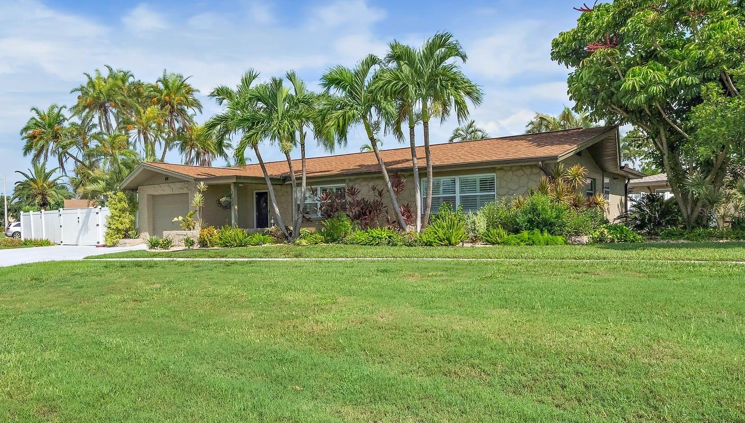 Fabulous Pool Home nestled in the heart of the coveted Tierra Verde community; this stunning home offers the perfect blend of modern updates and tropical charm. Located at the southern tip of St. Petersburg, Florida, Tierra Verde is renowned for its laid-back boating and fishing lifestyle, with direct access to nature and the beautiful Fort De Soto Park. Step inside to discover a fully updated kitchen featuring solid surface countertops, custom cabinetry, stainless steel appliances, a vent hood, and recessed lighting, all enhanced by high-quality fixtures. Both bathrooms have been elegantly updated with custom vanities, granite countertops, tile shower enclosures, and stylish fixtures and lighting. The home boasts diagonal tile throughout, creating a seamless flow from room to room. The spacious laundry room is equipped with built-in cabinetry for added convenience and storage. Outside, you'll find your own private tropical oasis. The lagoon-style pool is surrounded by lush landscaping, offering complete privacy, while the expansive lanai and pergola provide the perfect setting for outdoor dining or relaxing. There’s also an additional parking pad ideal for boat or RV storage. With its prime location, you'll have easy access to all Tierra Verde has to offer. The pristine Gulf beaches are just a short bike ride away, and you're only moments from some of the area's best fishing and nature spots. Plus, this home has not been affected by flooding, offering peace of mind for years to come. Whether you're looking for a seasonal retreat or a permanent residence, this home offers the ideal balance of luxury, comfort, and convenience. Pride of ownership is evident throughout – it’s a must-see!