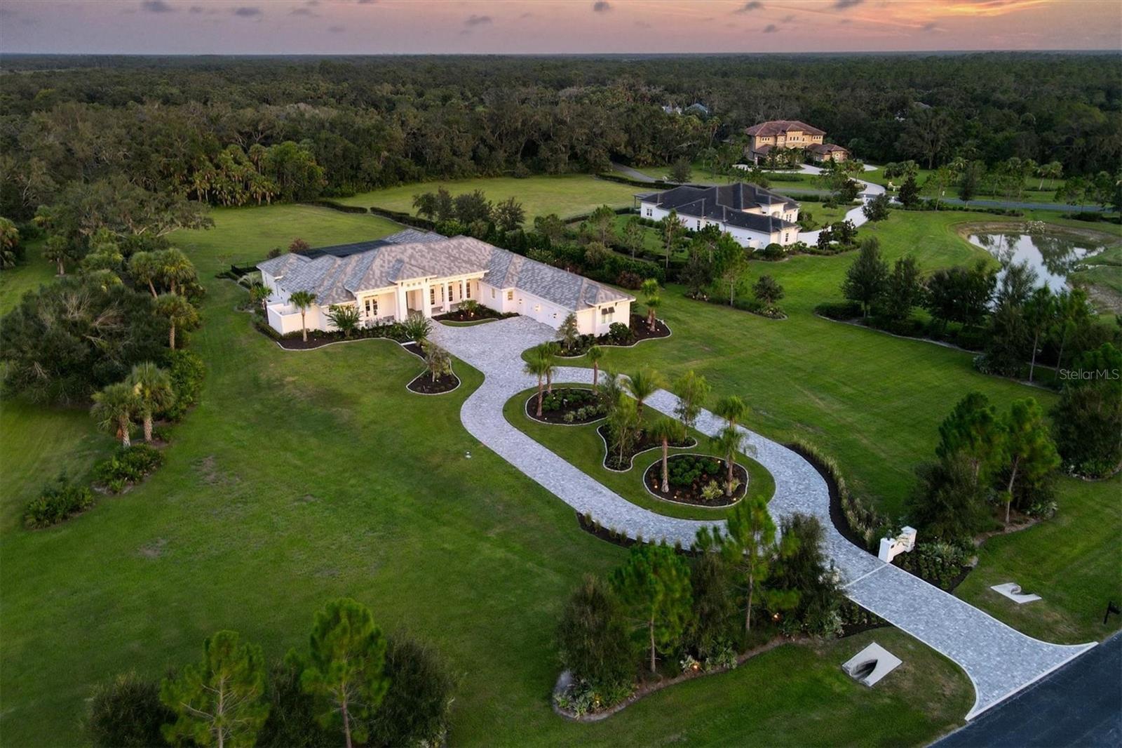 This custom-designed home, built by Anchor Homes, is a warm and inviting, Florida Coastal-style luxury home that offers a tranquil setting on a 4.38-acre lot in The Forest at Hi Hat Ranch. The Forest at Hi Hat Ranch is a gated community offering only 54 homesites with no two homes the same. Set on one of the last lots toward the rear of the community, the inspired floor plan of this home takes full advantage of the natural beauty of the land and its peaceful sceneries with all main living areas viewing the pool, lanai, and the lush surroundings this location offers. The exterior doors in the main areas of the home open to create a seamless indoor-outdoor Florida living experience. The home’s centerpiece is the spacious and inviting kitchen, great room, and dining area, featuring wood coffered ceilings in the kitchen, wood beams in the great room, custom hickory wood flooring (throughout the home) and a gas decorative fireplace. The kitchen boasts a 10-by-7-foot island with White Wave granite, a specialty refrigerator drawer, freezer/icemaker drawer, wine cooler, Bosch dishwasher, warming drawer, and microwave drawer. This showpiece area of the home is the perfect hub for daily activities and entertaining guests. The roomy owner’s suite overlooks the poolside and has a large double-entry closet with room for everything and more. The lavish master bath has a substantial walk-in shower, a separate soaking tub, dual vanities, and a private outdoor courtyard area with shower. All guest bedrooms have en-suite baths and closets already upgraded with organizers. The office has custom built-ins with a set of exterior doors, so you always have fresh sunlight and a view of the front yard. The den/TV room provides an additional space for relaxation and opens to the pool and lanai. The poolside bonus room/bedroom suite has a kitchenette and a full bath and is perfect as an in-law suite, an extended stay guestroom, or an additional office. The outdoor living area is enhanced by a fireplace, an outdoor kitchen, and multiple spaces for all types of outdoor furniture. The heated pool and spa invite you to enjoy the Florida lifestyle day and night. Imagine having a screened lanai that is approximately 1,900 square feet of outside living. This home also features a large inviting front porch, custom exterior doors, custom window coverings (including plantation shutters), wood cabinetry, 12-foot ceiling heights, Wolf appliances, luxury hickory hardwood flooring throughout, a large laundry room with sink, counterspace, and a specialty shower for pets and an extra-large three-car garage. Approximately 10 minutes to I-75 and about 25 minutes to Siesta Key; you will absolutely want to come and preview this private and tranquil lifestyle. You will immediately come to enjoy the quiet calmness of nature, birds chirping and deer who stop to watch you go by. Call for your private appointment today.