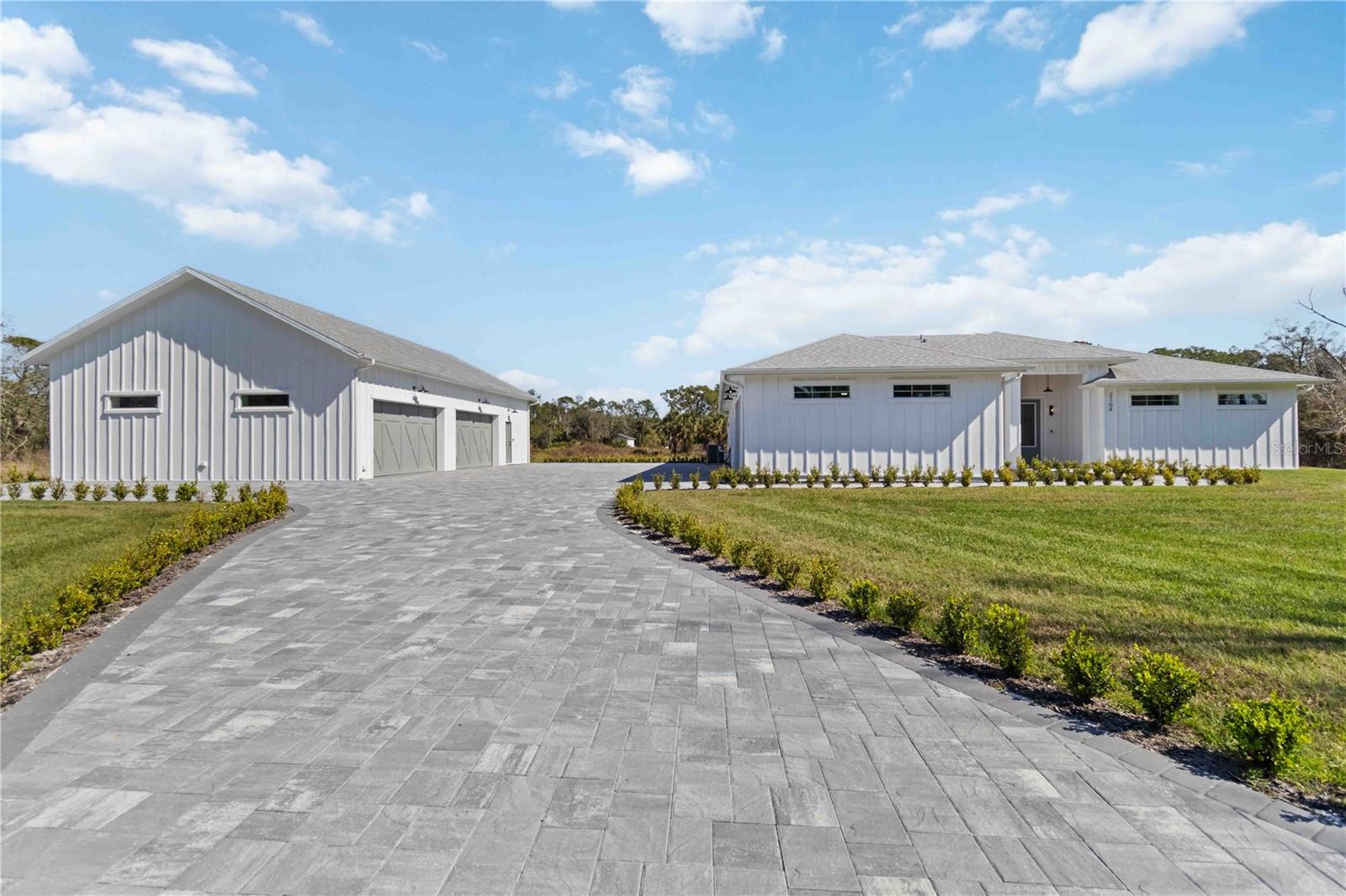 Dreaming of luxury, space, and privacy—all just minutes from the city? This one of a kind 2024 custom built farmhouse and guest house has a total of 4 bedrooms, 3 full bathrooms, 2 full size kitchens, XXL pool, and oversized 6 car garage meticulously designed for the most discerning tastes & over engineered with no expense spared. Custom interior features include: European white oak wire brushed wood floors, double stacked crown molding, full extension window & door casings, large baseboards, cypress tongue & groove walls & ceilings, 8’ solid core interior doors, knotty alder barn door doors, designer plumbing & light fixtures, walnut ceiling fans, level 5 drywall (silky smooth), fully dimmable lighting, quartzite countertops & backsplashes, knurled cabinet hardware, and soundproofing throughout. The gourmet kitchen features floor to ceiling cabinetry, white oak radius hood and island, cristallo quartzite countertops with full height backsplash, 2x convection ovens, 36” induction cooktop, 66” fridge/freezer column set, under-the-counter 30” microwave, pot filler, and ample storage. The secondary kitchen features floor to ceiling cabinetry, Taj Mahal quartzite countertops with full height backsplash, 36” built-in refrigerator, ice maker, 30” microwave, induction range with convection oven, and leathered marble floors. Spa-inspired bathrooms feature imported marble on the floors, walls, ceilings, wainscoting, floor to ceiling ½” thick shower glass with transom for steam showers, standalone soaking tub, and custom vanities. The laundry room features floor to ceiling cabinetry, 30” sink, ample storage, comfort height commercial washer & dryer, and quartzite countertop with full height backsplash. The bedrooms feature oak wood or marble flooring, cypress tongue & groove accent walls, and custom closet built-in. Exterior features include, resort-style lanai with cypress tongue & groove ceiling, marble deck, and 22’x35’ heated saltwater pool, 7’x35’ sundeck under a 30’x41’ panoramic pool cage. Every detail exudes relaxation and entertainment. Additional features include: detached guest house with private entrance and attached 4 car garage, 5,000 SqFt paver driveway/walkway/RV parking area with 50 amp receptacle, water & septic hook up, impact rated low-e insulated windows & doors, custom carriage house R-19 insulated garage doors, Kinetico commercial whole house RO system, spray foam insulation throughout, insulated interior walls, vertical board and batten on all exterior walls, 2x custom HVAC systems with whole house fresh air and dehumidification systems, 400 amp electrical service, solid poured concrete envelope with R-25 insulation on both sides, marine grade light fixtures, solid non-vented soffit, custom half round gutters, and cypress tongue & groove lanai & entry ceilings. Need storage for your toys? This property features a 19’x22’ garage with 10’ ceiling height and additional  28’x38’ garage with 21’ ceiling height, providing a total of 1,662 SqFt dedicated garage space. This property is not just a home—it’s a lifestyle. Come experience the peace, luxury, and space you’ve been dreaming of. Welcome to your own slice of Florida paradise!