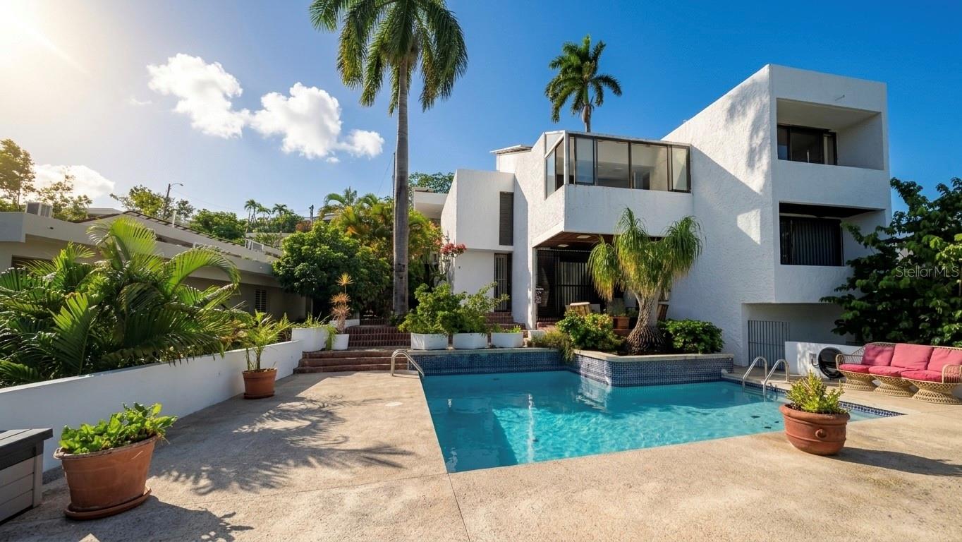 Virtually Staged. Villa Caparra Norte | Guaynabo, PR - Rare Opportunity – Iconic 3-Level Architectural Residence Awaiting Your Vision!

Bring your imagination and transform this property into your forever home. Nestled in the community of Villa Caparra Norte in Guaynabo, this stunning 3-level tropical architectural residence offers an extraordinary canvas for the visionary buyer ready to invest, transform, and personalize.

With 2,696 sq ft of living space, 10 rooms, 4 bedrooms & 4 full bathrooms on a Fee Simple lot of 661 M/C — this home is packed with lifestyle features that are simply hard to find.

Step outside to your own resort-style oversized pool — perfect for entertaining and living the Caribbean lifestyle at its finest. Sports enthusiasts will love the private basketball court, while the expansive patio offers endless space for al fresco dining and unforgettable gatherings under the Puerto Rico sky.

Inside, versatility reigns. The lower level features a flexible space ideal as a private gym, home office, or extra bedroom. A charming detached studio in the rear includes a private closet & full bath — perfect for guests, family, rental income, or a private retreat.

Upper levels lets you enjoy breathtaking panoramic views of the Guaynabo city skyline from the primary suite and its private balcony  — a daily reminder of why you chose this home.

Built with solid reinforced RC-CB concrete block, this distinguished 45-year-old residence boasts exceptional structure and enormous appreciation potential. Carport for 2 vehicles, formal dining room, utility room, terrace, fence & pool already in place — it just needs YOUR personal touch.

This isn’t just a house — it’s a legacy project. Rare 3-level residence in one of Guaynabo’s most coveted neighborhoods, priced to reflect the opportunity. Whether you’re an investor, a forward-thinking buyer, or a family searching for the perfect forever home — this is your moment.

Schedule your private tour today and start imagining the possibilities!