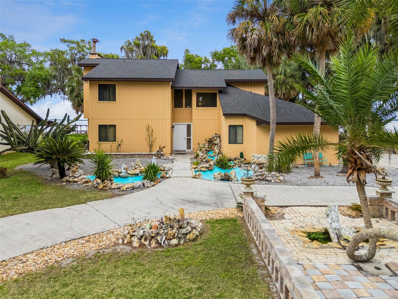 One or more photo(s) has been virtually staged. WELCOME TO LAKE FRONT LIVING-Experience the ultimate Central Florida waterfront lifestyle in this beautiful lakefront home in the
sought-after Waters of Lake Griffin community in Fruitland Park, Florida. Situated on a generous 0.52-acre lot with direct frontage on Lake Griffin,
this 4-bedroom, 3-bath residence offers approximately 2,470 square feet of thoughtfully designed living space and breathtaking water views. The
home welcomes you with impressive curb appeal, a circular driveway, and lush landscaping highlighted by a charming waterfall and pond feature
near the entry. Inside, the open floor plan creates an inviting space for everyday living and entertaining, featuring tile flooring throughout the main
areas and a spacious family room with a wood-burning fireplace. The well-appointed kitchen offers ample space for gatherings and flows
seamlessly into the living areas. Upstairs you’ll find additional flexible living space perfect for a home office, media room, or workout area, while
the downstairs layout offers versatility with a bedroom that can also function as a formal dining room. Outdoors, enjoy peaceful lakefront views
and plenty of room to relax, entertain, or store your boat or RV. With access to the scenic Harris Chain of Lakes, this property is a dream for
boating and fishing enthusiasts. This rare waterfront opportunity combines privacy, space, and stunning natural surroundings while remaining just
minutes from shopping, dining, and everything Lake County has to offer.