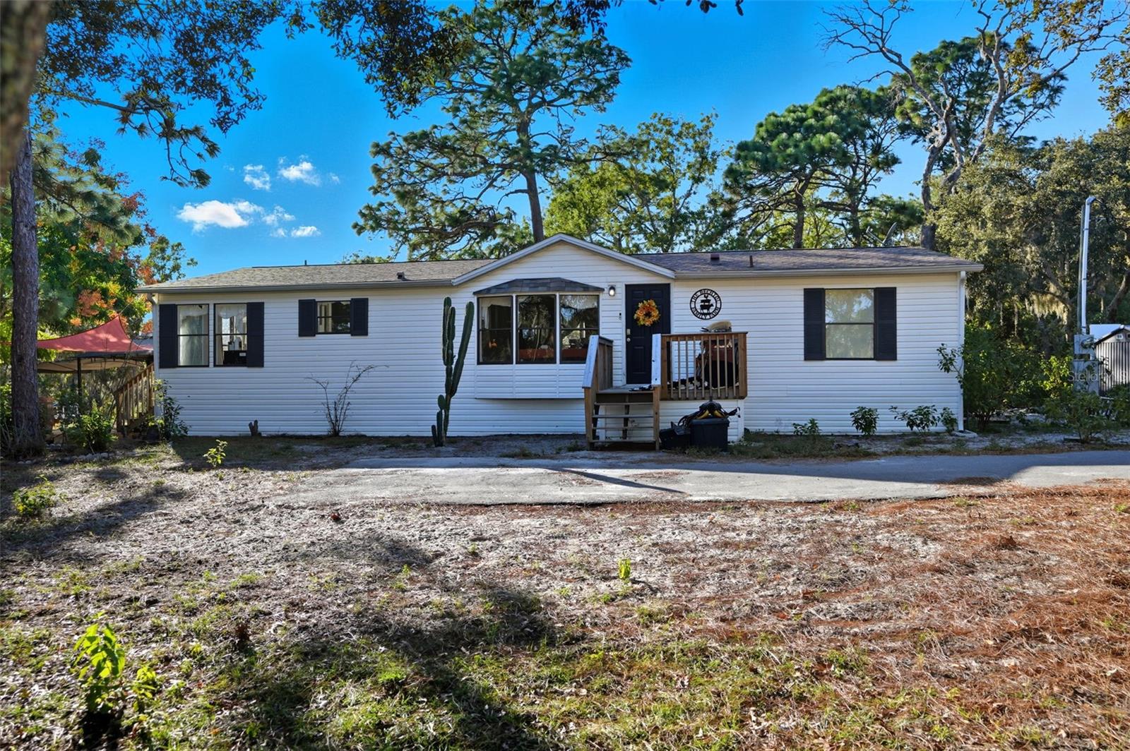 4 ACRE property in Highlands Subdivision in Hudson with an updated, 3 Bedroom, 2 Bathroom well-maintained manufactured home. Bring your farm animals and enjoy this non flood zoned usable 4 acres. As you enter through the gated entrance and drive up the long newer driveway to the stunning country setting you will impressed with the peace and quiet this property offers. The living room is adorned with a woodburning fireplace to take the chill off during our cooler winter days/nights and adds to the country charm of this home. Kitchen is large with updated cabinets. Primary bedroom is split from the two secondary bedrooms offering privacy. New Barndoors from the primary bedroom to the primary ensuite bathroom. ZONED AC AGRICULTURAL. NO HOA! NO CDD! ROOF 3 YEARS NEW. WELL HAS A 3 YEAR NEW WELL PUMP. SEPTIC- NEWER DRAIN FEILD IN THE LAST 8 YEARS. HVAC 2018. BOTH SHEDS STAY. Fully fenced property. This home is close proximity to 19 and county line, shopping, restaurants, medical. The pool, trampoline, and swing set will be removed prior to close.
