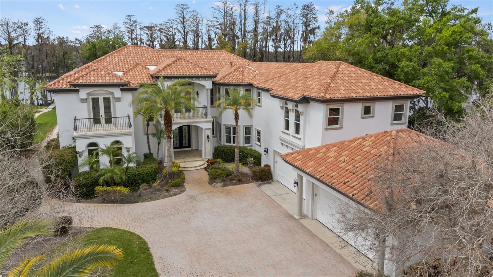 Set behind a long, palm-lined drive and privately positioned along the shores of ski-sized Lake Keystone, this extraordinary waterfront estate offers over two acres of secluded luxury—creating a rare retreat designed for privacy, recreation, and grand-scale entertaining.