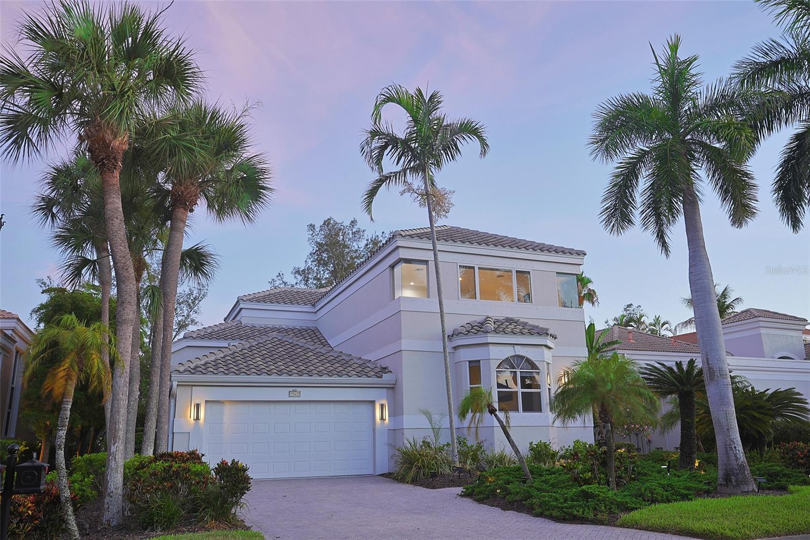 Experience refined coastal luxury in this impeccably renovated 4,154-square-foot golf course estate, ideally positioned within the exclusive Queens Harbour enclave of gated Bay Isles on Longboat Key. This extraordinary two-story residence offers 4 bedrooms, 4.5 bathrooms, and an elegant open floor plan thoughtfully curated with exquisite finishes and designer details throughout. Extensive recent enhancements include a newer roof (2021), new panoramic pool cage with picture-frame screening (2025), new hurricane Armor Screen shutters protecting every opening (2025), and a custom two-person Pneumatic Vacuum elevator, along with numerous additional upgrades and improvements.

Dramatic two-story windows fill the expansive great room and chef’s kitchen with natural light while showcasing breathtaking views of the sparkling pool, serene lake, lush landscaping, majestic oak trees, and the manicured fairway. Designed for both everyday living and entertaining, the gourmet kitchen is a culinary masterpiece, complete with a large gas range, dual ovens, solid wood cabinetry, abundant counter space, and a charming breakfast nook framed by bay windows overlooking the pool and golf course.

The luxurious first-floor owner’s retreat offers Brazilian cherry wood flooring, vaulted ceilings, French doors opening to the lanai, dual walk-in closets, and a spa-inspired bathroom. Two additional guest bedrooms on the main level are connected by a beautifully appointed Jack-and-Jill bathroom.

Outdoor living is equally exceptional, with an oversized pool and spa set within a spacious private lanai designed for relaxation and entertaining while enjoying tranquil sunsets over the lake and golf course. Residents of Queens Harbour enjoy maintenance-free living, a private community pool, and exclusive access to the Bay Isles Beach Club with deeded Gulf beach access. Ideally located near the Longboat Key Club Harbourside golf course, tennis facilities, and the Moorings Yacht Club, this residence embodies the finest in Longboat Key luxury living.