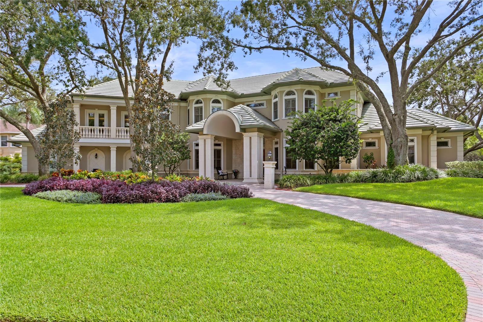This beautiful home located in the guard gated, golf and country club community of Avila is nestled on a 1 acre homesite with sweeping water front views. Designed with meticulous attention to detail by Alvarez Homes, this custom-built home spans 6,357 square feet of air-conditioned living space. This residence features a luxurious Downstairs Master Suite, an additional 3 Bedrooms, 4 Full and 2 Half  Bathrooms, a Home Office, a Movie Room, and a Screened-in Pool and Lanai. Upon arrival, the attention to detail is evident in the beautifully landscaped grounds, the circular driveway, and the grand double front entry doors that warmly greet you and your guests. The formal living and dining areas are thoughtfully designed for entertaining, highlighted by elegant columns, crown molding, wood flooring, and intricate millwork. The gourmet kitchen has been updated with professional grade appliances including an induction cook top, Wood Mode Cabinetry, Quartzite countertops, a breakfast bar and a kitchen dining room. The adjoining family room includes a fireplace, wet bar with beverage refrigerator and has French doors which open to your stunning screened in pool and lanai. The master suite on the main level is a sanctuary in itself, graced with new wood flooring, a fireplace, a cozy sitting area, and a master bathroom recently adorned with exquisite finishes. French doors open to reveal the breathtaking screened-in pool and lanai, seamlessly connecting indoor and outdoor living spaces.
The outdoor living area is a haven of relaxation, complete with a brand-new outdoor kitchen. The screened-in patio offers multiple seating areas to bask in the vibrant Florida sunshine. Come home to this gorgeous estate in Avila where you will find a lifestyle, security and privacy that is the best in Tampa Bay!