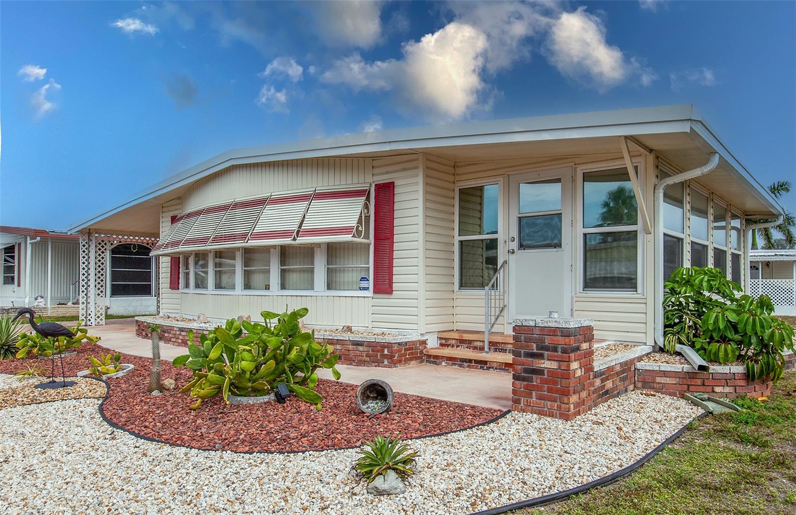 Welcome to this nicely landscaped and maintained 1,275 sq ft double wide long unit on a corner lot! The owners have updated the Air Conditioning System (2024), New Roof (2023), Windows for the Master Bedroom, 2nd Bedroom, Side Living Room, Kitchen and Lanai (2020), Garbage Disposal (2025), and more. Master Bedroom features an en-suite Bathroom, Vanity Area, and a Walk-in Closet.  The Guest Bathroom has its own Full Bath, with plenty of closet space. The Florida Room has Windows and Doors have Gila Titanium UV Blocking Film. The air-conditioned shed is spacious and contains the Washer and Dryer.  Just around the corner to the larger Clubhouse #2 for easy access to the Community Pool and Club.  Other amenities include a Fitness Center, 2 Heated Pools, 2 Hot Tubs, Saunas, Putting Greens, Shuffleboard, Bocce Ball, Miniature Golf, Art Rooms, Pool Room, TV Lounges, Card Rooms, Library, Horseshoes, Ceramic Kilns, 2 Huge Ballrooms, Sunday Services and much more!
Venice Isle is the premier resident owned over 55, Manufactured Home Park in Venice. There are close to 1000 homes with the most active residents. Come by for a visit to one of the spacious units in the inviting Venice Isle!