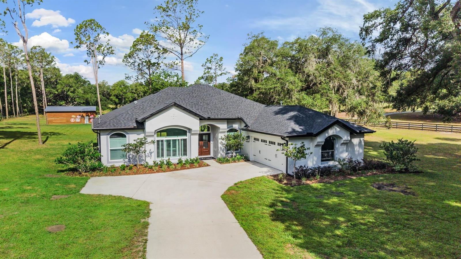 One or more photo(s) has been virtually staged. Tucked away on 5 breathtaking acres in the heart of Dade City, this extraordinary estate is the definition of luxury country living with every modern convenience close at hand. Every inch of this remarkable property has been thoughtfully redesigned with impeccable craftsmanship, timeless style, and absolutely no detail overlooked. As you pull into the property, the sprawling landscape, mature trees, and wide open skies create a picture perfect setting that feels like your own private retreat. Step through the front door and you are instantly welcomed by a bright, open concept layout filled with natural light, upscale finishes, and refined touches throughout. Every space flows effortlessly into the next, creating the ideal blend of warmth, sophistication, and functionality. The heart of the home is the beautiful kitchen featuring custom cabinetry, striking countertops, premium appliances, and an oversized gathering space, this kitchen was made for entertaining while still feeling comfortable for everyday living. The spacious living and dining areas highlight the quality of the renovation and provide picturesque views of the surrounding property. The expansive primary suite is a true retreat, offering the perfect balance of luxury and tranquility. With generous space, a walk in closet featuring custom built in storage and a spa inspired ensuite that elevates the experience even further with a massive glass enclosed walk in shower, freestanding modern soaking tub, and carefully selected finishes that create a relaxing, resort style feel, altogether providing the ultimate private sanctuary to unwind and recharge at the end of the day. The dedicated office offers the perfect work from home setup, tucked away for privacy while still feeling connected to the home. Each of the secondary bedrooms has been tastefully updated, creating comfortable and inviting spaces, while the additional two bathrooms have been transformed with elevated finishes and thoughtful designer details that enhance the overall feel of the home. Step outside and the magic of this property truly unfolds. The expansive acreage provides endless possibilities for those dreaming of space, freedom, and a true country lifestyle. Bring the horses, chickens, and livestock because this welcoming community embraces farm life and all the charm that comes with it. The impressive 30x40 barn, complete with electric and water, is ideal for animals, hobbies, equipment storage, workshops, or creating the ultimate recreational space. Whether you are enjoying quiet mornings overlooking the property, hosting family gatherings under the stars, or simply taking in the peaceful surroundings, this estate offers a lifestyle that is becoming increasingly hard to find. Located just minutes from the historic charm of downtown Dade City, you will enjoy easy access to local boutiques, restaurants, coffee shops, farmers markets, and community events that make this area so beloved. Convenient access to the interstate also makes commuting simple, while the nearby Wesley Chapel area offers endless shopping, dining, entertainment, hospitals, and everyday conveniences just a short drive away. This is more than just a home, it is a fully reimagined lifestyle property where elegance meets wide open space, and where every detail has already been perfected for you. A/C 2026, WELL BLADDER 2026, WELL HOUSING 2025, SEPTIC SYSTEM/TANK 2025, ROOF 2024, WINDOWS 2024, WATER HEATER 2024, AND MUCH MORE!