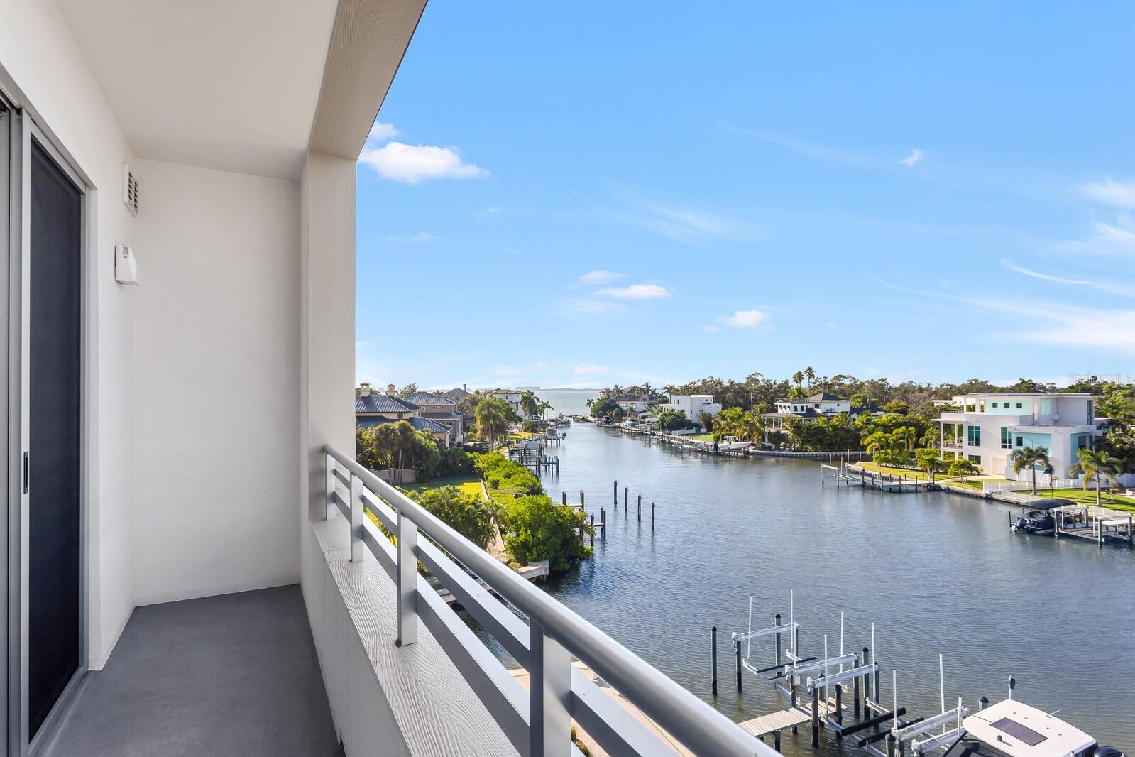 Experience this breathtaking penthouse waterfront condominium with sunset views in the resort style gated complex, The Strand. With direct boating access to the Bay and Gulf of Mexico, serene water views, option to purchase a deeded boat slip with 16,000# lift, five-star amenities and fantastic proximity to Downtown Sarasota and area beaches, this residence affords a second-to-none waterfront lifestyle. This unit features a prime location in the Strand in the building closest to the bay and on the 5th floor providing incredible views! The 1 bedroom + office/den, 2 full bath open floor plan features upgraded finishes, custom closets, sizable living area, dining area and open-air terrace. Perfect as a primary or secondary home, or investment property where weekly rentals are welcome. Entertain in your chef's kitchen with stainless Samsung appliances, upgraded white subway tile backsplash, soft close cabinetry, statement quartz countertops and 2 generously sized peninsulas with room for seating. The main living space has incredible natural light and affords stunning water views through 9' hurricane-rated sliding glass doors. This smartly designed home boasts a serene primary bedroom with custom closet, luxe owner's bath with quartz vanity, and laundry area with stackable Samsung washer and dryer. Office/den with closet perfect for all of your organizational needs and an additional full bath with tub. Other noteworthy features: custom designed closets, pendant lighting, and designer ceiling fans. Includes 1 deeded under building parking space, and private secure storage. Welcome to The Strand, brought to life by renowned architectural firm HOYT, and award-winning interior design firm JKL Design Group. Fantastic resort style amenities including heated swimming pool/spa, fitness center, gas fire pit and grills, electric car charging stations, dog park, boardwalk, and kayak launch & storage. In addition to the fabulous surroundings and culture of Downtown Sarasota, you can enjoy the restaurants, cafes and bars that are just a stone throw away from The Strand. Live THE lifestyle exploring top-rated beaches and bays. Make this exceptional residence, community and city your home today!