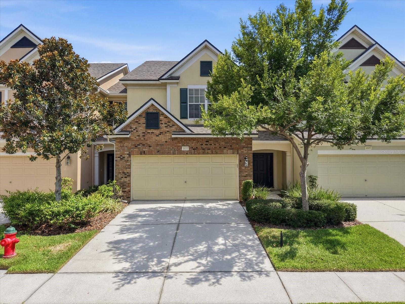 Expansive pond views, solid concrete block construction on both levels, a two-car garage, and one of the best locations in Valhalla set 4611 Pond Ridge Drive apart from the typical townhome. Perfectly positioned on a premier pond-front homesite in this gated Riverview community outside of downtown Tampa, this 3-bedroom, 2.5-bath home sits directly across from one of the community pools, restrooms, large covered patio area, and mailboxes, with ample guest parking just steps away. Inside, a dramatic two-story atrium entry welcomes you with a chandelier, open staircase, and smart under-stair storage. Custom picture-frame molding, crown molding, tile floors, and engineered hardwood create an elevated first impression, while upgraded carpet adds comfort on the stairs and second floor. Nearly every room captures sweeping pond views, filling the home with natural light and creating a peaceful backdrop for daily living, working from home, and entertaining. Tinted windows help improve privacy and enhance comfort, while a custom living wall with an automatic sprinkler system adds a memorable designer feature. The kitchen blends style and function with upgraded wood cabinetry, decorative crown molding, hardware, granite countertops, generous prep space, and a built-in coffee bar with added storage. Updated appliances in 2016, plus a newer dishwasher and microwave. The open layout connects the kitchen, dining, and living areas, making it easy to host friends, enjoy family time, or relax with the water views. Upstairs, the spacious primary suite overlooks the pond, while two additional bedrooms offer flexibility for children, guests, a home office, or fitness space. The upstairs laundry room features custom cabinetry and a new washer and dryer, and multiple storage closets help keep life organized. Unlike many townhomes with wood-frame second stories, this home offers concrete block construction all the way up, providing added durability, sound insulation, and peace of mind. Updates include a new roof, professionally serviced HVAC with an active service contract, a newer water heater, newer toilets, and a two-car garage with epoxy-coated floor, newer garage door opener, and custom built-in storage. Valhalla offers exceptional HOA value for low-maintenance living. Monthly dues include water, sewer, trash, lawn care, exterior maintenance, pest control, cable, high-speed internet, gated entry, two pools, poolside restroom and covered patio areas, and the community master insurance policy. Because the HOA carries the exterior master policy, homeowners typically only need an affordable HO-6 interior policy. The home is also in Flood Zone X, so flood insurance is not required, and there is no CDD fee. The community also plans holiday activities and food truck nights, adding neighborhood connection without sacrificing privacy. Located minutes from I-75 and the Selmon Expressway, this move-in-ready Riverview townhome offers easy access to Downtown Tampa, MacDill Air Force Base, and Brandon. Everyday destinations including Target, Costco, EoS Fitness, Publix, Sprouts Farmers Market, Winthrop Town Centre, restaurants, and shopping are just down the street. For buyers seeking a gated Riverview townhome with pond views, a two-car garage, concrete block construction, premium upgrades, low ownership costs, and everyday convenience near Tampa, 4611 Pond Ridge Drive delivers lifestyle, value, and location.