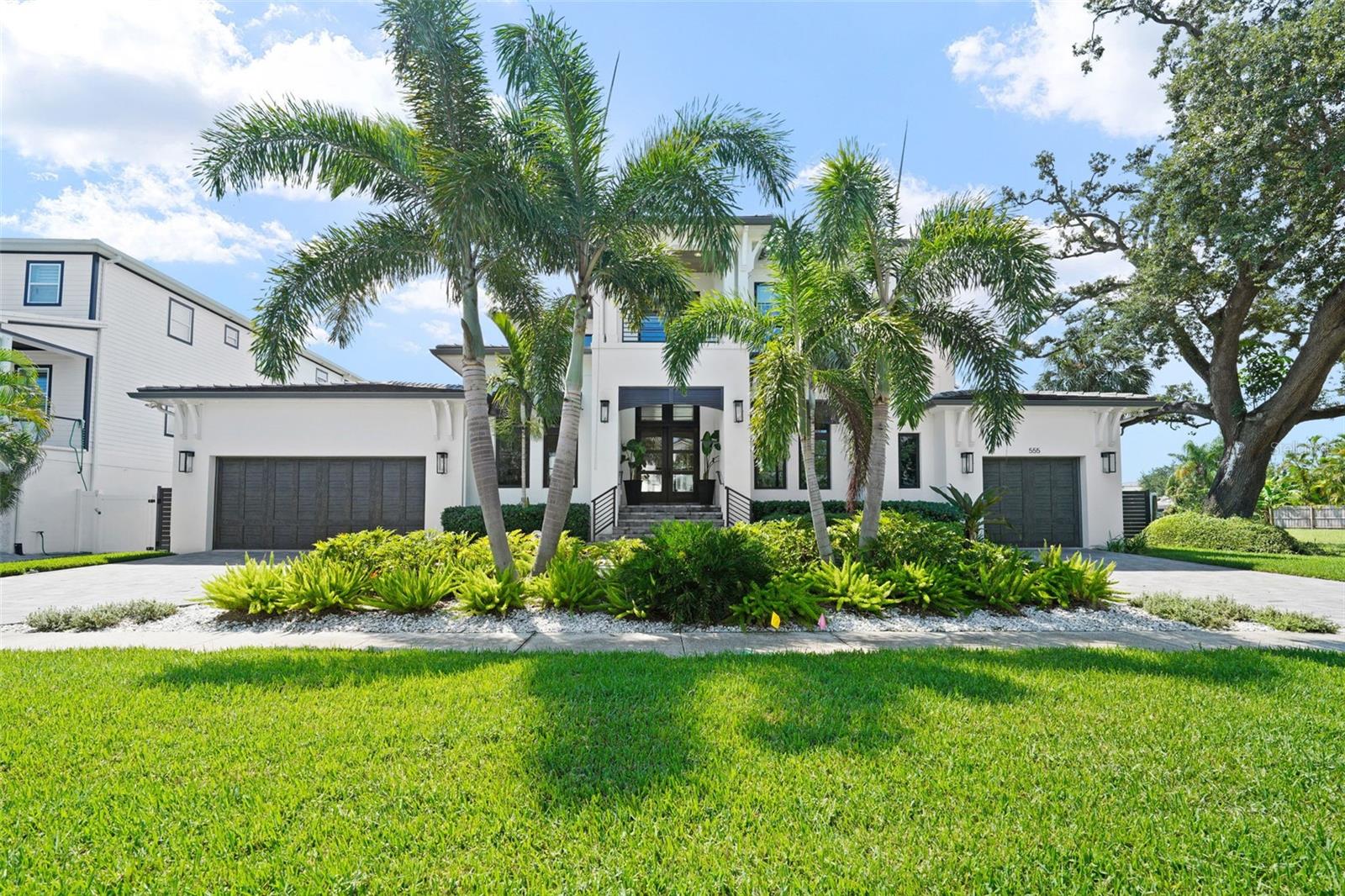 Davis Islands Modern Coastal on 100’+ of Waterfront with first-floor master bedroom. This custom-built residence blends timeless design with the highest standards of craftsmanship and is located on a quiet street on Davis Islands. The entry showcases a custom contemporary mahogany six-panel front door with impact glass and transom, opening to light-filled interiors defined by white oak engineered hardwood floors. A glass-fronted refrigerated wine cellar—with split-system cooling, floor-to-ceiling wood tile, stainless steel wine racks, a mahogany solid wood door, marble floors, custom cabinetry, and an electronic lock—serves as both functional storage and a striking design feature. The chef’s kitchen pairs marble counters and backsplash with premium appliances, complemented by a butler’s pantry and walk-in pantry. Living areas flow seamlessly to the outdoors through a 4-panel impact pocket slider, while PGT high-impact bronze windows with transoms on the front and rear elevations frame every view. Every element of the home reflects thoughtful engineering and luxury detail—from its piling foundation and concrete flat tile roof to the light sand finish stucco and custom Bahamian shutters with crafted metal railings and fencing that frame the façade. The primary suite offers two walk-in closets and a spa bath finished with imported marble flooring, counters, and shower, plus a freestanding soaking tub. Additional bedrooms include en-suite baths with marble finishes, continuing the home’s refined material palette.. At the water’s edge, a new seawall supports a composite dock with a covered 13,500lb boat lift—finished with a metal roof, lighting, water, and electric service. An additional electric 1,500lb lift lowers directly into the water, easing access for boating or water toys. The backyard is south-facing, enjoying full sun year-round, making it ideal for sunbathing, entertaining, and effortless pool enjoyment. This space is a showcase for Florida living: a contemporary rectangular saltwater pool with water-edge spa, glass waterline tile, umbrella stand, lounge area, and automated Hayward LED lighting. Surrounding the pool and lanai, silver travertine pavers set the stage for gatherings. The lanai’s cypress coffered ceiling frames a linear gas fireplace with a tabby shell stucco surround and a custom barnwood mantel, while a custom outdoor kitchen—featuring a Blaze grill and smoker with a double hood, stainless steel backsplash, beverage center, concrete counters, sink, and an Ipe wood surround—makes entertaining effortless. A plumbed outdoor shower with hot and cold water completes the resort feel. Six gas lanterns accent the entry and garages, bringing coastal character to evening hours. The oversized three-car garage offers versatility with a deep two-car bay (workbench and storage included) and an extended one-car garage sized for a golf cart. A whole-house generator ensures comfort and security year-round. Come enjoy the DI lifestyle with its walking and bike path, and just a short distance away from Davis Islands Village with many restaurants, shops, and bars. Bring your golf cart and enjoy the Island lifestyle with baseball fields, public tennis courts, a public historic pool, two dog parks (one wet and one dry), a beach, a public marina, and an airport. Located only minutes from Downtown Tampa, Water Street, Sparkman Wharf, and the Tampa Riverwalk, this neighborhood is the most desired in South Tampa!