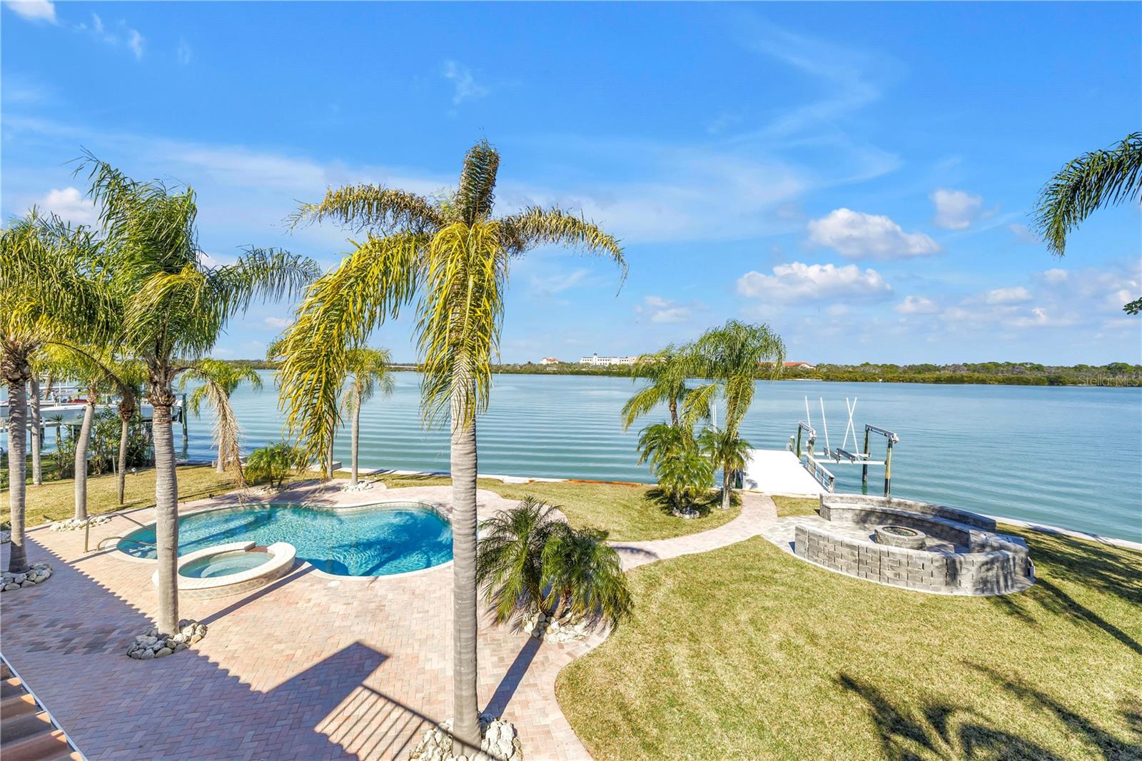 Where open water views meet privacy... A lifestyle-driven, wide-open-water estate with resort outdoor living.  Positioned where water becomes horizon and privacy becomes absolute, this exceptional Madeira Beach estate offers a level of seclusion rarely found on the Gulf Coast. End-of-the-road placement with preserve frontage ensures uninterrupted views, enduring privacy, and no future development risk.
Beyond its refined aesthetic, the residence has been comprehensively remodeled with an emphasis on longevity, flow, and peace of mind. During renovation, the original water-facing wall and Northeast wall was thoughtfully removed to open the home to expansive water views, creating a new luminous dining area and living experience. Enhancements include a 2021 barrel tile roof, new impact windows and sliding glass doors along the waterside, a newer HVAC system, new electrical panel (2021), all new appliances, including a gas stove with a pot filler, and fully reimagined bathrooms throughout—ensuring the home is as sound as it is beautiful.
Outdoors, a resort-style pool is surrounded by expansive paved patios, a one of a kind fire pit surround, and all of this is framed by water on three sides, offering an ideal setting for both intimate gatherings and grand celebrations. This spot gives you a front row seat to the most Spectacular Christmas Boat Parades.  Nearly 160 linear feet of deep-water seawall, dual 10,000-lb boat lifts, and direct Gulf access with no fixed bridges create a true mariner’s haven.
Set within a peaceful enclave of Madeira Beach, yet moments from world-class dining, shopping, new luxury development, a short drive to both St. Pete/ Clearwater airport and Tampa airport and the forthcoming Madeira Beach Marriott Autograph Hotel, this residence offers the rare balance of tranquility and proximity.  For buyers seeking a waterfront home that combines location, lifestyle, and meaningful upgrades for long-term confidence—this is a compelling opportunity in today’s market.
This is Gulf Coast living—elevated.