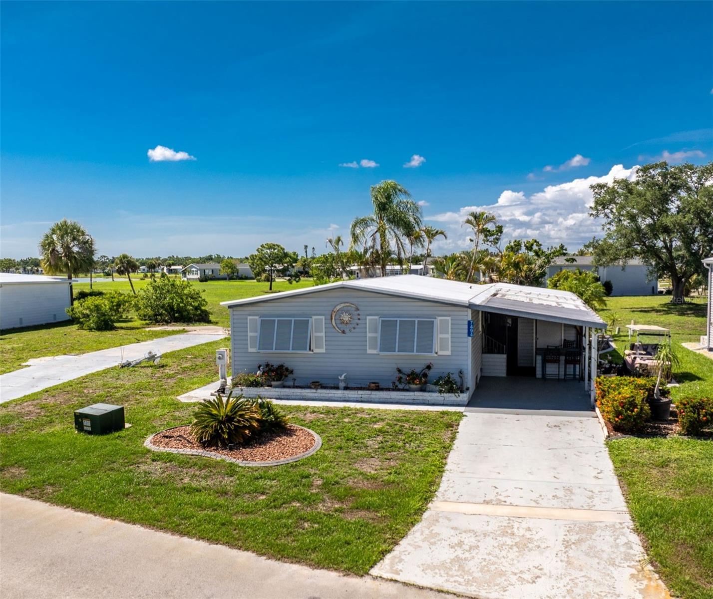 Welcome to this beautifully maintained, TURNKEY furnished home in the highly sought-after Village of Holiday Lake, where you OWN YOUR OWN LAND and enjoy peaceful lake views in a vibrant WATERFRONT COMMUNITY. This spacious residence features  a rare 16' x 17' BONUS ROOM under air, providing flexible space for a family room, hobby area, home office, or additional guest accommodations.

Designed for both comfort and entertaining, the home boasts an open, light-filled layout with a spacious living room featuring an electric fireplace, a separate dining area with built-in cabinetry, and a well-appointed kitchen offering abundant cabinet and counter space, plus a large pantry. This home is ready for immediate enjoyment, whether as a year-round residence, seasonal retreat, or investment property.

The primary suite features a walk-in closet and private bath, while the guest bedroom also includes a walk-in closet and can easily serve as a den or office. Pergo wood flooring, generous storage throughout, and indoor laundry add to the home's convenience.

Enjoy tranquil water views from the oversized bonus room or relax outdoors in your private patio oasis surrounded by tropical landscaping—perfect for grilling, entertaining, or simply soaking in the Florida sunshine. Storage is plentiful with three sheds, including one air-conditioned shed ideal for protecting valuables, tools, or hobby equipment.

Accessibility features include handicap-accessible entry, a wheelchair lift, and thoughtful accommodations designed for ease of living. Additional highlights include GOLF CART, Bermuda shutters, PLYWOOD SUBFLOORS in most rooms, and a NEWER ROOF with a lifetime warranty, offering added peace of mind.

The adjacent lot is also available for purchase, presenting a unique opportunity.

The Village of Holiday Lake is a welcoming, ALL AGES COMMUNITY known for its active waterfront lifestyle and exceptional amenities. Residents enjoy two community pools, a recreation hall, FITNESS CENTER, tennis and PICKLEBALL courts, shuffleboard, woodworking and craft rooms, BBQ areas, and a full calendar of social activities. Boating enthusiasts will appreciate ACCESS TO CHARLOTTE HARBOR AND THE GULF through the community's canal, along with COMMUNITY BOAT SLIPS. Conveniently located near beaches, golf courses, shopping, dining, and entertainment, this property offers the perfect opportunity to embrace the Florida lifestyle in a friendly, golf cart-friendly neighborhood where ownership, recreation, and relaxation come together.