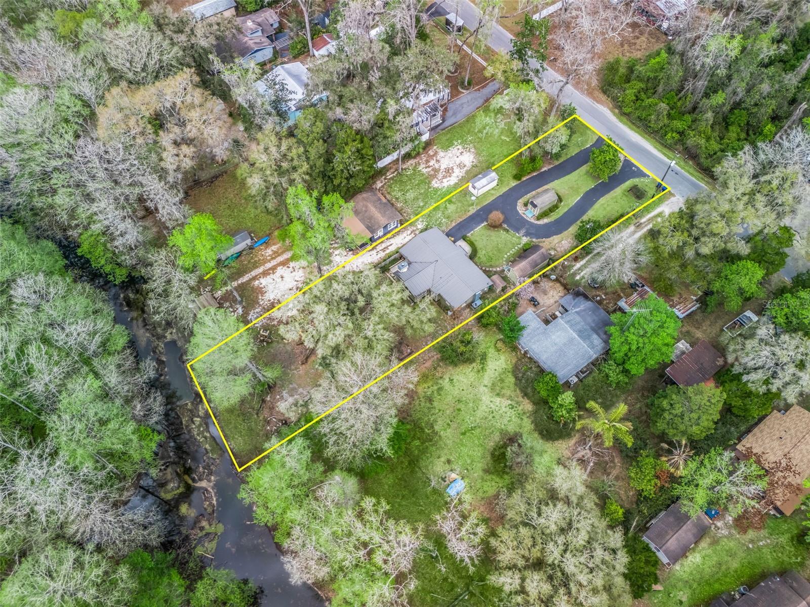Seller will consider a $10,000 credit at closing toward buyer concessions!
Welcome to a peaceful riverfront retreat where comfort meets natural beauty. Situated on a .35-acre lot. This 2-bedroom, 1-bath home invites you to slow down and enjoy the view, with warm oak wood floors and pine ceilings creating an inviting sense of charm from the moment you step inside. The den serves as a welcoming gathering space, centered on a cozy wood-burning fireplace and framed by large windows that let in soft natural light with calming views of the river and surrounding trees. The eat-in kitchen offers both style and efficiency, featuring granite countertops, a tumbled marble backsplash, a gas range, and generous cabinetry designed for easy everyday living. The bathroom continues the refined feel with marble tile flooring and a walk-in marble shower. Every detail reflects care and simplicity, from the private well with a water filtration system to the workshop/she-shed-laundry space, 5-ton HVAC, storage shed, and enclosed whole-house generator. This home is both comfortable and easy to maintain. A home security system is in place, featuring cameras and motion sensors installed on the perimeter of the home, along with a monitoring system set up inside. A paved circular driveway and carport add ease of access and everyday convenience. Outside, the setting encourages a relaxed outdoor lifestyle. With nearby access to Hog Island and the Withlacoochee State Forest, opportunities for kayaking, fishing, scenic walks, biking, and quiet wildlife viewing are just a short distance away. Conveniently located with access to I-75, US 301, US 41, W CR 476, and US 98, travel to Brooksville, Inverness, Ocala, The Villages, and Tampa is easily within reach. The home offers the feel of a tranquil getaway while remaining close to shopping, dining, entertainment, and medical facilities, making it ideal for either a full-time residence or a peaceful seasonal escape. Whether you are seeking a quiet place to settle in year-round or a private retreat to enjoy seasonally, this riverfront home offers the perfect balance of comfort, nature, and convenience. Come experience the calm for yourself and discover what makes this setting truly special.