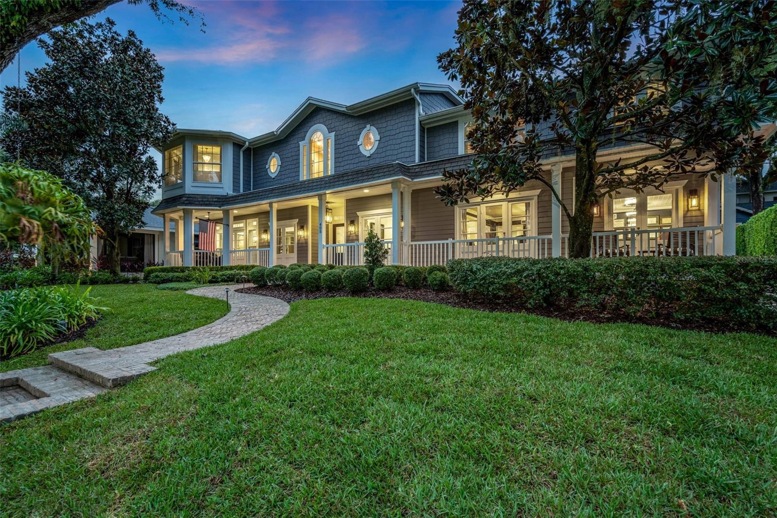 Stunning Lakefront Estate with Unmatched Craftsmanship and Timeless Elegance. Welcome to this extraordinary Cape Cod-inspired estate, perched above picturesque Lake Ivanhoe with sweeping views of the downtown Orlando skyline. This 5,811 sq ft masterpiece is a blend of timeless design and modern luxury, offering everything you’ve dreamed of in a home.. As you step through the grand entrance, be prepared to be captivated by the soaring two-story ceiling, a stunning staircase, and the exquisite woodwork that adorns every corner. The home boasts 4 spacious bedrooms, 3.5 beautifully appointed bathrooms, and two versatile office spaces—one of which could easily serve as a 5th bedroom. 
The home’s layout effortlessly combines elegance and comfort. The spacious chef's kitchen is a culinary dream, featuring top-of-the-line appliances, a large picture window overlooking the sparkling pool, and a seamless connection to the informal dining area and family room, which boasts a custom dry bar—perfect for entertaining. Adjacent to the kitchen, the butler's pantry provides an exceptional level of convenience with a secondary dishwasher, oven, and its own laundry area, making hosting large gatherings a breeze. Additionally, a walk-in pantry provides ample storage. Serenity abounds throughout the home, with breathtaking lake views from nearly every room. The expansive screened-in patio offers a seamless transition to outdoor living, perfect for al fresco dining by the heated saltwater pool and outdoor fireplace.

As you ascend the stairs, you are greeted by a serene sitting area with floor-to-ceiling windows that capture the peaceful beauty of Lake Ivanhoe.
The primary suite is a true sanctuary, featuring an oversized sitting area, custom his-and-hers closets, and a spa-like bathroom with heated Calcutta Gold marble floors, a soaking tub, and a multi-head steam shower. A private laundry room and an additional office or gym space add convenience to this serene retreat. Beyond the sitting area, a true loft space awaits—perfect for a playroom, media center, or additional workspace. This space leads to three generously sized bedrooms, including an impressive junior suite with its own custom walk-in closet, luxurious ensuite bath with Carrara marble and a stunning stained-glass window.

Every detail of this home has been thoughtfully designed, from the extensive use of crown molding and shiplap to the floor-to-ceiling windows that flood the home with natural light. The Cape Cod charm is highlighted by a sprawling 70-ft front porch, elegant herringbone brick walkway, and beautifully landscaped grounds with indirect lighting.

Located just steps from the heart of downtown Orlando, this home is walkable to popular shops, dining, and top-rated schools, including Lake Highland Prep and Bishop Moore. Enjoy the best of both worlds with the tranquility of lakefront living and the convenience of city life. This is the home that checks every box on your wish list—don’t miss your chance to make it yours.