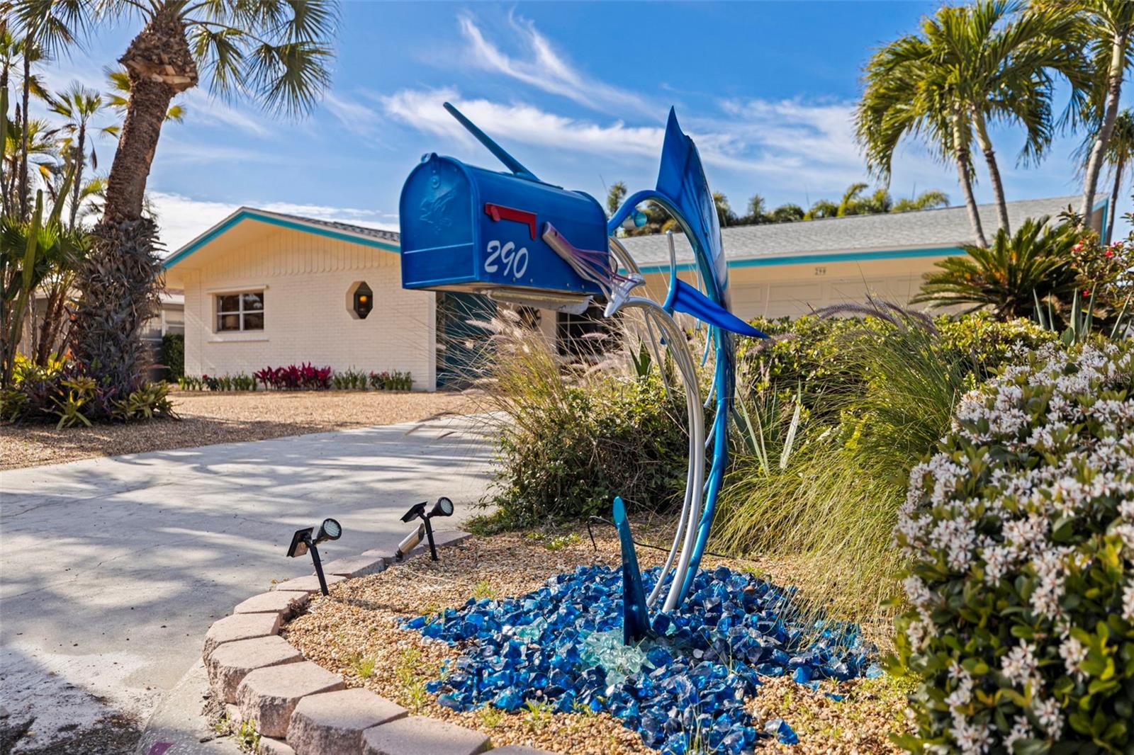 MID-CENTURY … MODERN … and MAGICAL! From the iconic Sailfish mailbox – a Tierra Verde landmark – to the colorful Chihuly-like handblown glass doorknobs and cabinet pulls throughout this amazing residence, you will be enchanted by the creativity and charm found in this unique and artsy one-level ranch home. With a base elevation of 9-ft, this home did not take on water during the 2024 storm season. This solid block construction home has ROOM FOR A POOL and is located on one of the most desirable streets on the island … directly across from multi-million-dollar waterfront homes on Boca Ciega Bay. Lovingly and meticulously designed for island living, relaxing and entertaining … no detail has been spared! 

As you enter through sleekly styled turquoise double doors, you’ll be impressed with the custom built-in design features that flow throughout the property: A dining cabinet that spans the entire wall with glass display cabinets and LED lighting, an entertainment unit complemented with embossed crown molding and interior lighting; and a coastal kitchen with navy blue flecked stone counters, quality cabinets and pantry space with pull-out shelves, a stainless steel backsplash, matching stainless appliances and under cabinet lighting. Recent upgrades include a Trane HVAC (2025), a hot water heater (2020) and a brand-new epoxy floor in the garage.

A 660 sq-ft addition to the back of the home (2017) with its own mini-split heat pump system provides tons of extra entertaining space and features a wall of windows that bring the outdoor oasis inside. The flooring is gorgeous beige honed and filled Travertine tile … beachy, beautiful and easy to maintain. A wet bar and second stainless refrigerator accompany light Ash cabinets with pull-out drawers and interior lighting, whimsical blown-glass cabinet pulls embedded with fish and coral, and sea-life art tiles to frame out the backsplash! Both full baths (the primary bath is ensuite) mirror the modern feel and celebrate the sea:  Glass shower doors with fish, sea turtles and undersea foliage and unique eclectic lighting fixtures. 

The primary bedroom in the back of the home features a laminate wall system that houses a California-King platform bed, dual nightstands with pull-out shelves, interior LED lighting and storage bins. Two other bedrooms in the front of the home have built-in closet systems and porcelain tile floors. 

A lush, private shaded backyard features a brick lanai with gazebo, two storage sheds, an outdoor shower, and is bordered with native plantings and flower beds. (Spa has been removed and does not convey.) The yard has landscape stone everywhere, no grass to cut! A 2-car garage connects to a workshop space, providing a sanctuary for artisans and craftsmen. Fully airconditioned, the garage and workshop can be utilized year-round.

TIERRA VERDE IS A SPECTACULAR ISLAND PARADISE tucked quietly away with easy access to everywhere … Head west within minutes to award-winning Gulf beaches, tiki bars and fun beachside attractions. Only a 10-minute drive to downtown St. Pete with its cultural attractions, sports venues, entertainment and fabulous restaurants. Fort DeSoto, offering an array of sugar sand beaches, fishing, camping, kayaking and miles of nature trails, is right down the Pinellas Bayway! And it’s only 30-40 minutes via I-275 to both international airports: TPA and SRQ. Schedule a showing today for an opportunity to own this unique and creative piece of paradise.