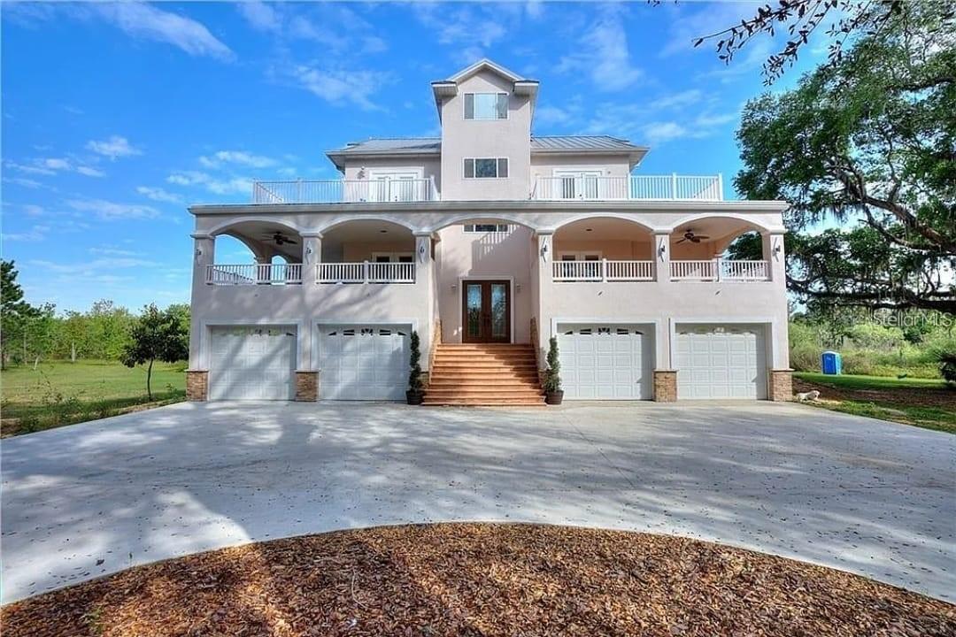 Style, quality, and value! Have you dreamed of living the good life? This is your oasis—nearly 20 acres. Own your piece of paradise in a 7,000± sq. ft. home that combines the charm of country living with a formal entertaining floor plan, featuring a luxurious dining room, living room, and office that extend to wraparound balconies on two floors. The custom-built gourmet kitchen boasts an island, walk-in pantry, and stunning views of the surrounding woods. Additional highlights include a four-car garage, a master suite with his-and-hers closets, two elegant master baths, and soaring ceilings throughout. A sweeping curved staircase leads to the second and third floors, offering four bedrooms, 5.5 baths, and laundry rooms on both upper levels. Call for a private tour of this magnificent home.