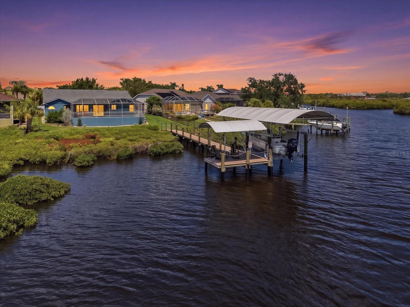 Discover your DREAM WATERFRONT RETREAT! This lovely 4-bedroom and 2-bath home offers the perfect blend of modest luxury, craftsmanship, and everyday coastal serenity. Perfectly positioned along the water’s edge, this beautifully updated home is located in the tree lined community of Braden River Lakes. A hidden treasure, this property is tucked in the desirable back portion of the community which offers effortless access to the Manatee River and the Gulf by boat. Elevate your waterfront lifestyle with newer decking, pilings, & boat dock, along with brand new lighting and a shade-producing dock cover. Boating enthusiasts will appreciate the 13,000 lb. custom remote boat lift, water depth, running water, and a 30-amp utility outlet. Whether you are heading out for a morning cruise or hosting a sunset gathering, this space is designed for both convenience, adventure and relaxation. Upon entering this truly immaculate home you are welcomed with immediate gorgeous views of the water. Added extras are the gleaming wood floors, vaulted ceilings and a custom designed gourmet "chef's kiss" kitchen. Perfect for entertaining and as functional as it is stunning. The kitchen is outfitted with TOP-OF-THE-LINE Viking appliances including a 6-burner gas range, lovely high cabinetry with under lighting, sleek quartz countertops, and a breakfast bar that opens to the eat-in space and family room. If you are hosting a larger gathering there is also a front sitting room and traditional dining room. The spacious primary bedroom has an ensuite bath with soaking tub, large separate shower, a nice sized walk-in closet and a separate doorway out to the beautiful, enclosed pool. The other side of the home offers separate space for family and guests with 3 additional bedrooms and full bathroom with a convenient door that also opens to the pool. Step outside to your fully enclosed patio and beautiful private pool oasis. Perfect for lounging or soaking in the coastal breezes in the nature like preserve setting. Every detail of this property has been thoughtfully upgraded for comfort, low maintenance and peace of mind: newer hurricane-rated windows and garage door, landscaping, a durable polyaspartic-coated garage floor, and epoxy coated pool patio deck. Braden River Lakes also offers great community amenities. The playground, pickleball-tennis courts and pool are only a short stroll away. Convenient shops and great dining options are right down the street, and don't forget about Anna Maria Island, Sarasota and Siesta Key, all only a short drive away. DO NOT miss out, this move-in ready and meticulously updated WATERFRONT GEM offers a rare opportunity to live the lifestyle you’ve always imagined.