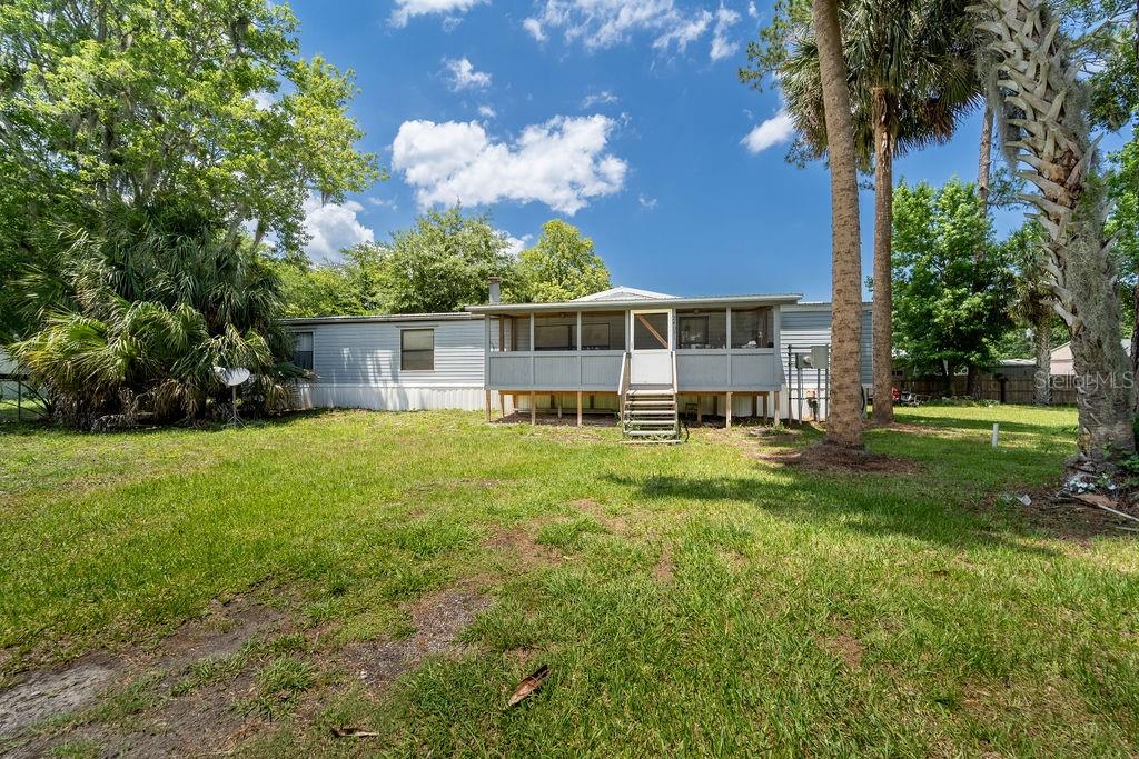 Spacious double-wide manufactured home with 1,864 sq. ft. of living space just minutes from the beautiful St. John’s River! This home offers a large living area, an eat-in kitchen, and a formal dining room—perfect for family gatherings or entertaining. The primary suite boasts a huge master bathroom with a garden tub, separate shower, abundant wood cabinetry, and a walk-in closet. Three additional bedrooms, a second full bath, an inside laundry room, and a cozy wood-burning fireplace add to the home’s comfort and functionality. Best of all, this property sits on your own land with no HOA or deed restrictions. For just $40 a year, you’ll enjoy access to the community boat ramp for easy trips to the St. John’s River. Don’t miss this opportunity to own a spacious home near the water with freedom and convenience!