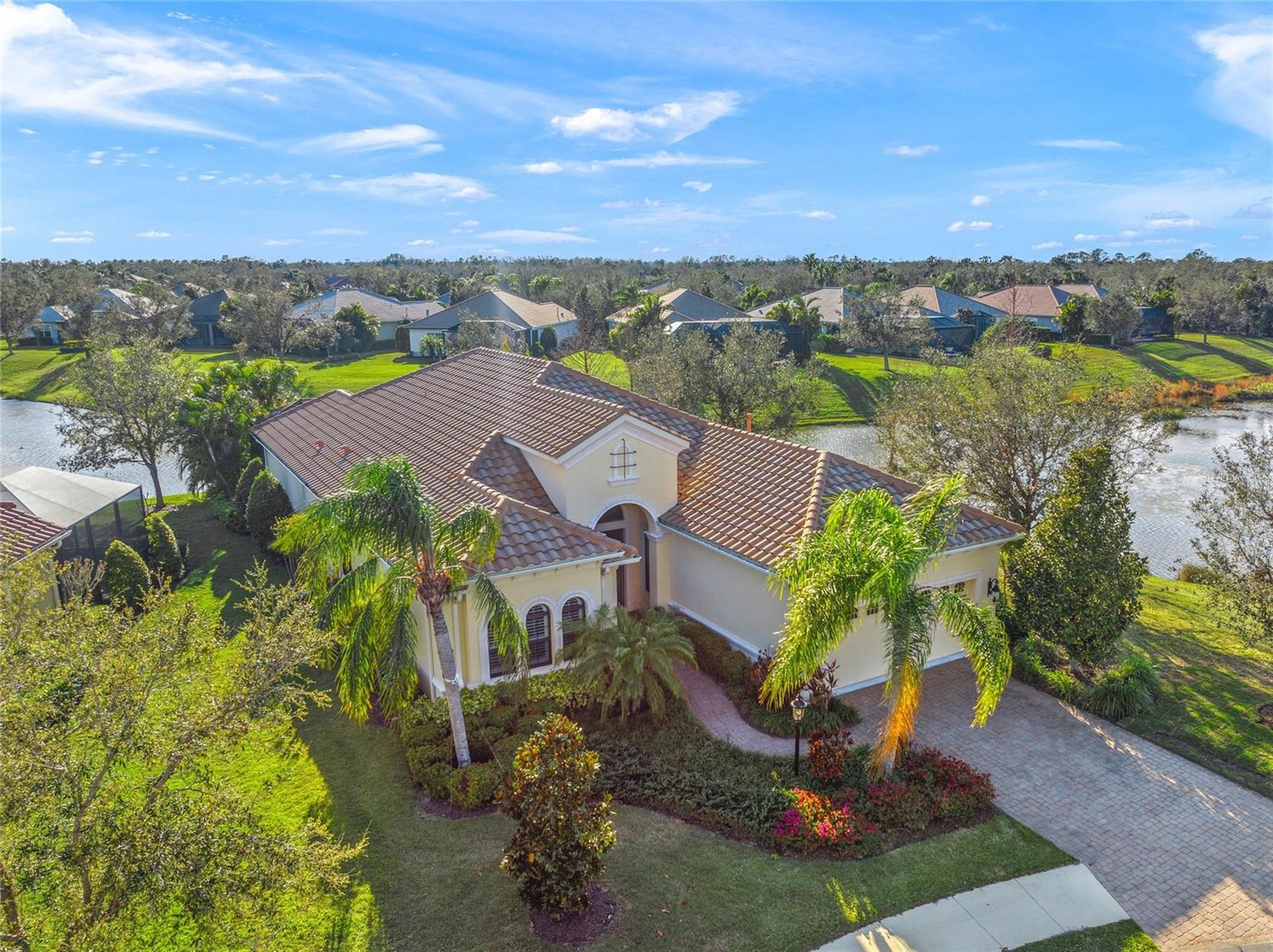 Driving through the gates of prestigious Country Club East, you will arrive at the Viano del Mar built by Neal Signature Homes. This meticulously maintained three-bedroom custom residence, complete with an office-den and 2.5 baths, is on a private cul-de-sac, offering peace and tranquility. As you enter through the double entry doors, you will be greeted by a grand foyer and gallery leading you into the elegant dining area and sprawling great room where your eyes meet serene outdoor living. This one-owner home features extraordinary quality on the exquisite corner lot, overlooking 180-degree scenic lake and greenbelt views. Over a quarter acre, the lushly landscaped property enhances the sense of privacy. Each room is adorned with decorative detail, volume ceilings, rich crown moldings, distinct open spaces and an abundance of natural light throughout. Window treatments, plantation shutters and automatic, custom Silhouette blinds adorn windows and sliding glass doors. The kitchen would delight the cultivated epicurean, showcasing stainless steel appliances, custom wood cabinetry, granite counters and sprawling breakfast bar, overlooking the sparkling, turquoise heated pool and spa. A well-appointed main-level primary suite offers a retreat with two walk-in, custom closets, a bay window and en-suite bath with dual sinks, granite, walk-in shower and soaking tub. Additional amenities include a spacious laundry room, paver walkways and patios, storm shutters, front impact glass windows and automatic poolside awning. The expansive outdoor living space is ideal for entertaining, complete with an outdoor kitchen for alfresco dining. An exemplified level of perfection that is entirely uncommon. Residents can enjoy community amenities at The Retreat, with a clubhouse, fitness center, resort-style pool and nature walking trails. Available Lakewood Ranch Country Club membership, two clubhouses, fitness centers, restaurants, three 18-hole championship golf courses, tennis, pickleball, lap pool, along with social events. Ritz Carlton Club memberships, with Tom Fazio-designed 18-hole championship course as another option. Conveniently near Waterside, University Town Center, dining, shopping, schools and parks are conveniently minutes away. Enjoy visiting westerly white sandy beaches, barrier islands and easy access to Interstate 75 and Sarasota International Airport.