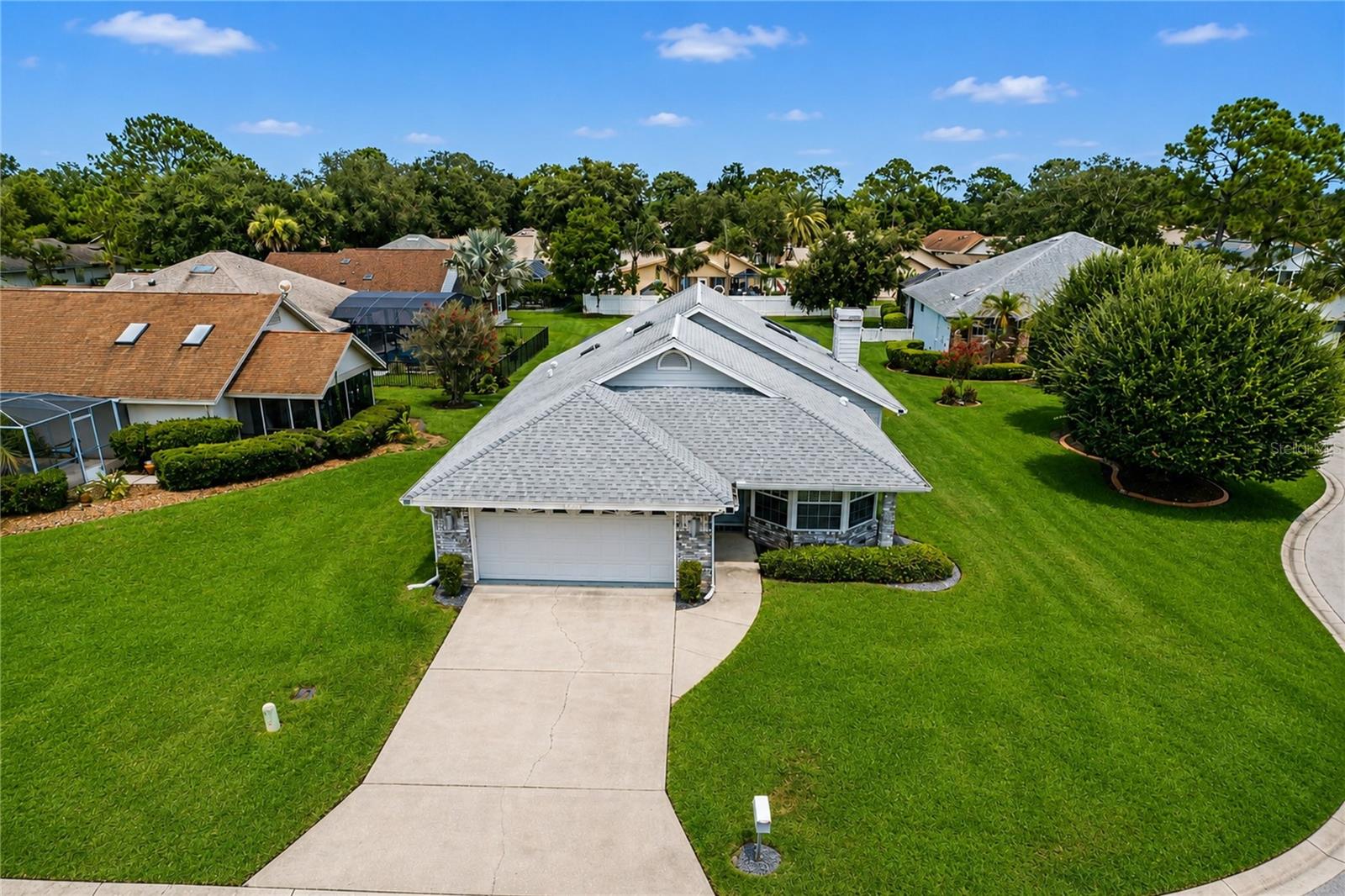 Just shy of 1/2 acre, one of the largest and most desirable homesites in Turtle Point, this exceptional property is ideally positioned at the entrance of a cul-de-sac with beautiful lake views and expansive green space. The premium oversized lot offers endless possibilities, including room for a detached workshop, artist's studio, hobby building, or future home expansion. No flood insurance required. This well-maintained pool home offers vaulted ceilings, skylights, a wood-burning fireplace, spacious living and dining areas, and a granite kitchen. Primary suite features a walk-in closet and updated bath with granite countertops and a walk-in shower. A screened pool and covered lanai overlook the expansive backyard, creating the perfect outdoor retreat. Major updates include a 2025 air conditioning system, 2016 roof and skylights, 2023 refrigerator, 2018 front entry door and living room sliding glass doors, 2015 water heater, plus Lexan hurricane panels for added storm protection. Located within the prestigious 24-hour guard-gated Spruce Creek Fly-In, residents enjoy access to a private airport, parks, walking and biking trails, children's playground, Overlook Park on Spruce Creek River, and optional country club membership featuring golf, tennis, pickleball, fitness, swimming, dining, and social activities. Conveniently located near shopping, restaurants, medical facilities, beautiful beaches, and within an A-rated school district, this rare Walker-built home combines a premium oversized homesite with one of Central Florida's most sought-after lifestyle communities. Cut and paste the following link to see video of home: https://listings.nextdoorphotos.com/vd/256756266