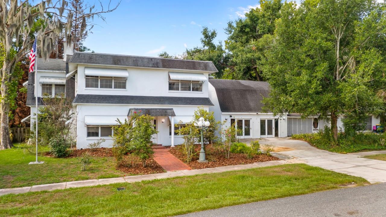 Situated on a rare oversized 0.68-acre double lot in the highly sought-after community of Howey-in-the-Hills, this one-of-a-kind property presents an incredible opportunity to create the home you've always envisioned. Offering over 2,360 square feet of living space (4,000+ total sqft), this estate is filled with character, generous room sizes, and endless possibilities for renovation and customization. Whether you're dreaming of restoring its timeless charm, designing a modern showpiece, or creating a multigenerational retreat, this property provides the ideal canvas to bring your vision to life. The spacious 4-bedroom, 2.5-bath home also features two large enclosed porches, an in-ground pool, a basement, and multiple detached structures (one has a floored attic) that offer exceptional flexibility for hobbies, storage, a home-based business, guest accommodations, or creative workspace. The detached 34' x 25' garage offers the potential for up to four vehicles, while two additional buildings can easily serve as workshops, studios, offices, or other versatile uses. Surrounded by mature trees, the expansive lot provides a private, picturesque setting that's increasingly difficult to find. Step through the enclosed front porch with its classic terrazzo flooring—a welcoming space perfect for relaxing with family and friends. Inside, you'll discover a spacious living room featuring original hardwood floors, a wood-burning fireplace, and ample room for entertaining. The adjoining dining room continues the home's traditional charm, offering a wonderful foundation for thoughtful updates while preserving its unique character. Located in one of Lake County's most scenic lakeside communities, you'll enjoy convenient access to Florida's Turnpike, Little Lake Harris, parks, golf courses, shopping, dining, and local gathering spots, all while enjoying the tranquility of an established neighborhood. Properties offering this much space, flexibility, and renovation potential on an oversized lot are a rare find. Whether you're an investor, a visionary homeowner, or someone looking to create a truly custom residence, this exceptional property is ready for its next chapter. Don't miss this incredible opportunity to transform this distinctive estate into your dream home. Schedule your private showing today!