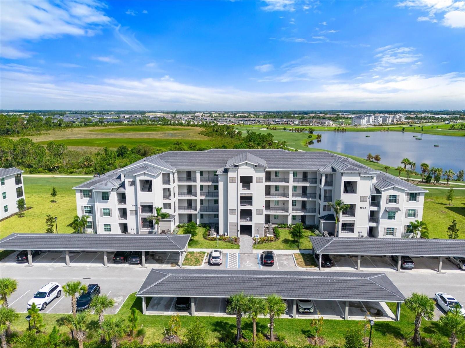 Live the ultimate Florida lifestyle in this bright and inviting first-floor condo at the highly desirable Wellen Park Golf and Country Club. Built in 2023, this 3-bedroom, 2-bathroom home offers an open-concept layout filled with natural light and modern finishes, creating a welcoming and comfortable space from the moment you enter. The kitchen is designed for both style and function, featuring stainless steel appliances, elegant shaker-style cabinetry, and quartz countertops that extend seamlessly into the bathrooms for a polished, cohesive look. A generous center island makes entertaining friends or enjoying casual meals effortless. Tile flooring throughout the main living areas, ceiling fans, and custom window treatments add to the home’s move-in ready appeal, while the screened lanai provides serene lake and golf course views—perfect for morning coffee, afternoon reading, or relaxing evenings outdoors. Additional features include a deeded covered carport, a private storage unit across the hall, and ample guest parking for visitors. Ownership also includes full golf memberships for two adults at the championship 18-hole course. The community continues to grow with resort-style amenities including a clubhouse, sparkling pool, tiki bar, fitness center, and tennis courts, all designed to support an active and social lifestyle. Located just minutes from Downtown Wellen Park, enjoy easy access to dining, boutique shopping, live music, farmers markets, scenic walking and biking trails, and some of Florida’s most beautiful Gulf beaches. This condo combines comfort, convenience, and modern Florida living in a vibrant and welcoming community.