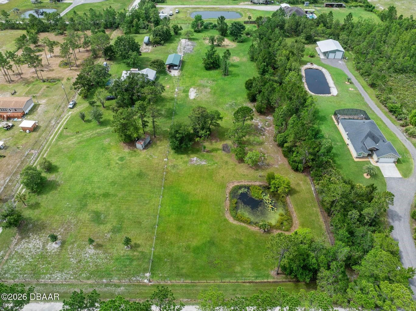 Discover the perfect place for your custom home or dream hobby farm on this remarkable 2.5-acre parcel on Budd Road. Nestled in a peaceful, highly desirable acreage pocket of New Smyrna Beach, this pristine property offers a rare combination of country serenity and coastal convenience. Unlike typical vacant lots that require extensive clearing, high site-prep costs, and significant time, this land has been lovingly cleared, manicured, and meticulously maintained for decades. The breathtaking, park-like setting creates an immediate sense of home, featuring a picturesque private pond, lush tropical banana trees, mature landscaping, and abundant native wildlife. Enjoy frequent visits from deer, wild turkey, sandhill cranes, and other Florida wildlife that make this property a true natural retreat. The land is fully fenced for privacy and security, with the neighboring property recently installing a new fence along their eastern boundary, further enhancing the property's appeal.


The lot is high and dry with optimal elevations and no wetlands to help ensure a smooth building process. With no HOA restrictions, you'll enjoy the freedom to create the lifestyle you envision, whether that's a custom home, hobby farm, detached workshop, or equestrian retreat.
Location is everything, and this property delivers the best of both worlds. You're just minutes from the beautiful beaches, shopping, and dining of New Smyrna Beach while enjoying convenient access to Sanford, the airport, and the greater Central Florida area.
Pruned to perfection and truly ready for your vision, this exceptional property stands in a league of its own. Acreage parcels maintained to this immaculate standard are exceedingly rare. Schedule your private tour today. This is an opportunity you won't want to miss!