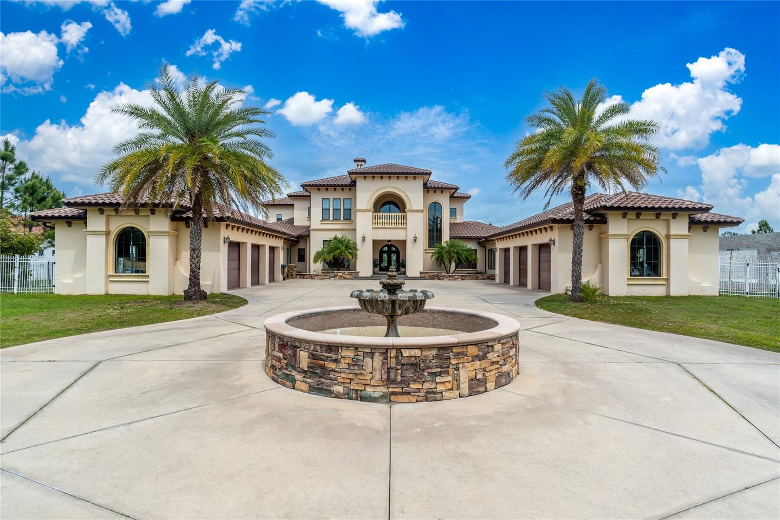 Experience the perfect blend of Mediterranean luxury, resort-style living, and serene lakefront privacy at 5251 Carson Street in Saint Cloud, Florida. Nestled on nearly 6 gated acres along the spring-fed shores of Lake Hendon, this 10,000+ square foot Tuscan-inspired estate offers 8 bedrooms, 7 full bathrooms, and 2 half baths, combining architectural elegance with unmatched comfort. The home features exquisite finishes, including Italian travertine, Spanish porcelain, custom hardwood flooring, hand-carved stone fireplaces, hand-plastered vaulted ceilings, iron-cast railings, wood-beamed coffered ceilings, and a charming piano alcove. At the heart of the home is a gourmet chef’s kitchen equipped with professional-grade Electrolux appliances, a 6-burner gas range, commercial-grade hood, solid wood cabinetry, and a butler’s pantry. Entertain in style with a formal dining room, breakfast nook, multiple open-concept living areas, a wet bar, a custom cobblestone wine cellar, a media/theater room, and a billiards/game room. Wellness and relaxation are elevated with a private gym, sauna, and two expansive lanais—one screened-in with a full summer kitchen featuring a grill, fridge, and TV. The grand primary suite features a sitting area, a morning bar, dual oversized California closets, and a luxurious spa-style bath with dual vanities, an air-jetted soaking tub, a massive dual-entry shower with multiple body jets, and two separate water closets, both equipped with high-end auto-flush toilets w/ bidet for added privacy and convenience. Upstairs, a loft connects five spacious bedrooms, many of which have private balconies and en-suite baths, offering privacy and stunning lake views throughout. Outdoors, the resort-caliber amenities continue with a 1,000+ square foot saltwater infinity-edge pool with beach entry, heated spa, fountains, and lounging deck, alongside a full-size tennis court, basketball court, lush landscaping, and a private boat dock for fishing, kayaking, and lakeside sunsets. Located in a quiet gated estate community just minutes from Lake Nona, top-rated schools, SunRail, and Orlando International Airport, and surrounded by premier restaurants and venues like Nona Blue, Chroma, Boxi Park, Canvas, and The Wave Hotel, this extraordinary property is also available with a +1–2 year lease in place—giving you the option to enjoy instant investment income or transition into a luxurious private residence—offering a rare opportunity to own one of Central Florida’s finest lakefront estates. Financing closing cost credit available with preferred lender.