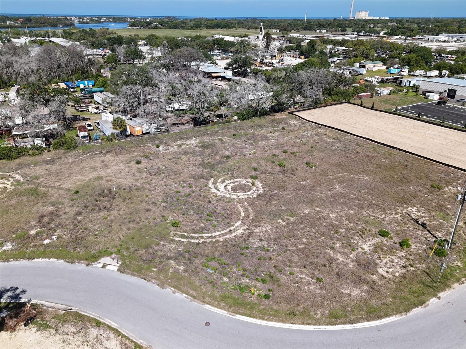 Positioned within the established River Bend Village Park in Tarpon Springs, this 0.63-acre vacant parcel offers a standout opportunity for industrial development. Its unique placement along North Bend Drive allows for exceptional visibility, with a layout that naturally draws attention from multiple vantage points - including passing traffic along nearby Anclote Road. This added exposure enhances both accessibility and brand presence, making it an ideal setting for businesses seeking a prominent footprint. With convenient access to US-19 and surrounding regional corridors, the property combines strong connectivity with long-term value. Whether you're building for your own operations or securing a strategic investment, this site delivers versatility, visibility, and growth potential.