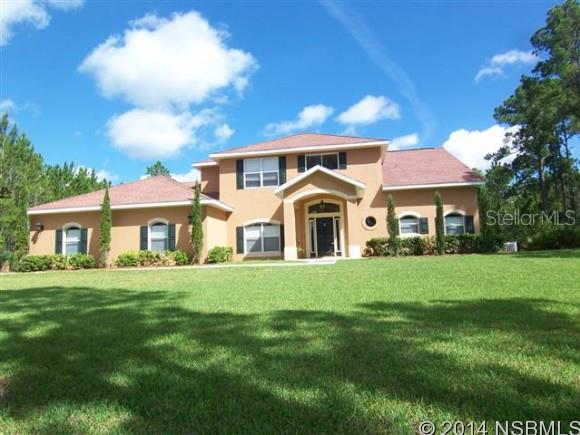 Port Orange Whispering Creek 3.32 Acre LUXURY HOME located among MULTI-MILLION DOLLAR ESTATES. Enter the grand foyer onto porcelain tile and 18 foot ceilings. You'll experience immediate views of the living room and GORGEOUS POOL and PROPERTY BEYOND. You'll also see that the open floor plan offers direct access to the dining room and HUGE GOURMET KITCHEN. The kitchen is filled with imported bullnose granite countertops, wood cabinetry, and top of the line stainless appliances, including double ovens. There is also a center island and terrific breakfast nook that overlooks the pool area. The living room has a wall of doors that leads to the lanai. The master bedroom is located on the first floor, has a 12x7 WALK IN CLOSET and an additional wardrobe. Just beyond the sleeping quarters is a sitting area perfect for enjoying the view of the property. You will love the master bath that is furnished with a walk- triple head RAINMAKER SPA SHOWER, jetted tub with INSTANT HOT WATER and double vanity. Also located on the first floor is the PRIVATE OFFICE or IN-LAW WING, and a BUTLER'S PANTRY with wine cooler, refrigerator, laundry room and pantry. Upstairs are three huge bedrooms and the third bathroom. The quality construction provides ENERGY EFFICIENCY through FOAM FILLED INSULATED BLOCK. The garage is oversized so that you can store your toys. HORSES ARE WELCOME and there are RIDING TRAILS. Measurements approx. and deemed to be correct.