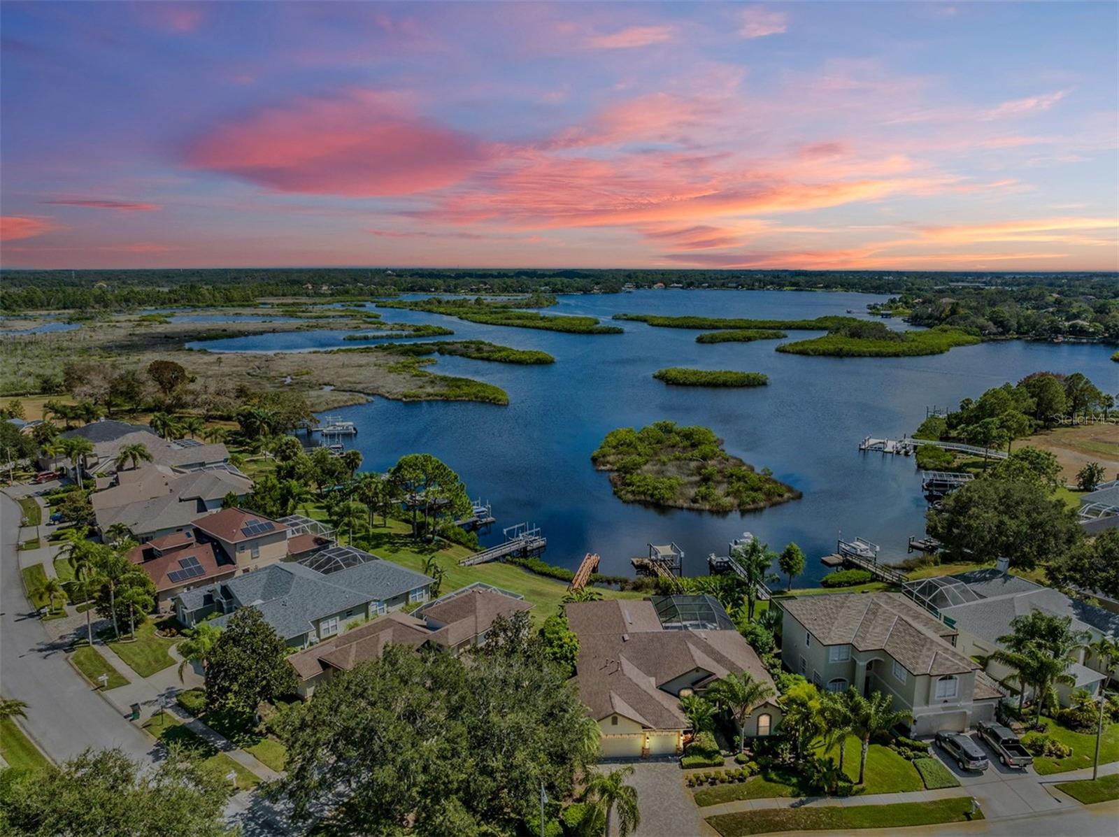 Calling all Boat lovers! If your dream is to Fish or Boat out your back door, this is it. Enjoy WATERFRONT Living in this 4 Bedroom, 3 Bath, 3 Car Garage POOL Home Nestled on a Lushly Landscape lot. Private Dock and Boat Lift awaits you for a hassle free Waterfront Lifestyle. With the Press of a Button, you can be out to the Gulf in no time! This Home offers Wonderful Curb appeal with a Brick Paver Drive and Decorative Stacked Stone. The minute you walk in to the Elegant foyer you will notice the Breathtaking Water views that overlooks the Anclote River from the Formal Living, Dining Room & Master Bedroom. This Home has been Updated and Meticulously cared for. Upgrades include Luxury Hardwood Flooring throughout with Crown and Base Moldings. You will be Impressed by the OPEN Split Floor Plan with Soaring Ceilings providing Natural Light, Custom Plantation Shutters and Arched Doorways. This Gorgeous Home features a Gourmet Kitchen which opens to the Family Room which is Great for Entertaining. Take in the Breathtaking Waterviews from the Sun Room right off the Large Family Room.  The Updated Kitchen features Granite Countertops and lots of wood cabinetry, Stainless Steel Appliances, Gas Range, Breakfast bar, Working Desk with Wine Storage above. Relax with a Cup of Coffee in the Breakfast Nook with Custom Built-in Seating and watch the morning sunrise. The Private Owner Suite features Tray Ceiling Crown Moldings, Large Walk-in Closet and En-Suite Bath with Dual sinks, Soaking tub and Separate Step-in Shower. The Split Bedroom Floor plan allows for an optimal set up for you and guests offering 3 additional Bedrooms with adjacent Baths. Enjoy the Large Sparkling Pool and Spill over Heated Spa (Natural Gas) featuring Travertine Decking (2017) and Covered Screened Lanai area. This Home is Move-in ready. The best part is that you can BOAT right outside your back door. There is an extended BOAT dock and boat LIFT allowing you to cruise down the Anclote river, and enjoy the beautiful scenery along the way to the open Gulf of Mexico. Upgrades include Roof 2016, Seawall 2014, and much more! River Watch community provides a private part, playground, picnic area. Conveniently close restaurants, shopping, Golf, Pinellas trail, the famous Tarpon Springs sponge docks, Honeymoon Island, State Park, and Clearwater Beach. You will enjoy endless opportunities for outdoor recreation and entertainment. Don’t miss out on this opportunity to own your slice of paradise.