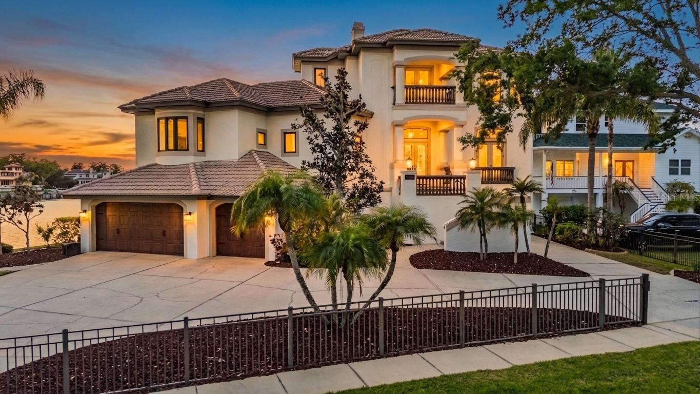 One or more photo(s) has been virtually staged. Nearly 300 feet of rare waterfront along Whitcomb Bayou and Spring Bayou highlights this exceptional Arthur Rutenberg custom estate with 4 bedrooms and 4.5 bathrooms. Designed to capture the beauty of its surroundings, the home showcases panoramic water views from nearly every room, creating a seamless connection between elegant interior spaces and the spectacular natural setting. The open floor plan is ideal for both everyday living and entertaining, featuring a formal dining area, oversized family room, and a chef’s dream kitchen outfitted with upgraded appliances and generous workspace. A charming breakfast nook is perfectly positioned to overlook the bayou, while a light-filled office offers a peaceful workspace surrounded by water views. Two guest bedrooms share a bathroom, while the split floor plan provides privacy for the primary suite, complete with a soaking tub, dual vanities, walk-in shower, private water closet, and spacious walk-in closet. French doors open to a sprawling waterfront deck overlooking the pool and expansive bayou views. Brand New Elevator services all 3 floors!  The third-floor additional primary retreat offers a luxurious private escape with an oversized sitting area, access to two private balconies, a wet bar, and an elegant ensuite bath featuring dual vanities, soaking tub, walk-in shower, separate water closet, and dual walk-in closets. The ground level offers four-plus garage bays, providing incredible room for recreation equipment, vehicles, golf carts, and water toys, along with 1,800+ square feet of additional uninsurable space. French doors provide convenient access to the pool area from both the main living level and the ground floor. Completing the waterfront setting is a boathouse and an additional dock with lift, ready to be redesigned by the new owner to fully maximize this exceptional boating property. From the moment you step outside, the home’s connection to the surrounding waterfront lifestyle becomes clear. Residents enjoy close proximity to Craig Park, featuring tennis courts, walking trails, a community center, boat ramp, and kayak launch, as well as the Tarpon Springs Yacht Club and nearby Fred Howard Park. Golf cart access leads to the historic Tarpon Springs Sponge Docks and vibrant downtown Tarpon Springs filled with restaurants, boutiques, festivals, and year-round celebrations. For boating enthusiasts, the adventure continues just beyond your dock. A short cruise down the Anclote River leads directly to the Gulf and some of the region’s most award-winning barrier island beaches, including the untouched shores of Anclote Key Preserve State Park and nearby Caladesi Island State Park, offering pristine sand, turquoise waters, and miles of undeveloped coastline rarely found along Florida’s Gulf Coast. The surrounding bayous are known for their natural beauty and vibrant marine life, where dolphins and manatees are frequent visitors and boating, fishing, and kayaking are part of everyday life. Each holiday season, the waterways come alive with the celebrated Tarpon Springs Christmas Boat Parade and the annual Epiphany Celebration—traditions that perfectly reflect the charm and heritage of this iconic coastal community. This remarkable residence offers a rare combination of architectural quality, expansive waterfront, and an unmatched Tarpon Springs lifestyle.