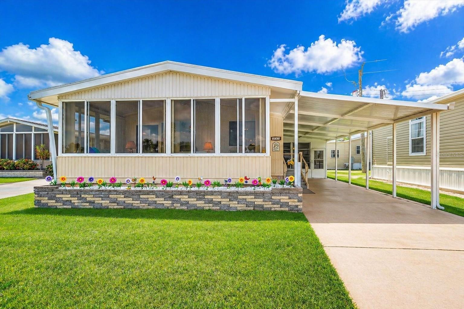 LAKEFRONT LIVING AT AN INCREDIBLE VALUE!  Wake up to peaceful water views and unwind year-round from your private enclosed lanai—featuring both screens and sliding windows—perfect for enjoying Florida breezes and watching wildlife in comfort.
This well-maintained 1983 Palm Harbor home offers 2 bedrooms and 2 bathrooms, with a spacious, light-filled living room and a comfortable kitchen and dining area ideal for everyday living or entertaining guests.  Major upgrade alert: a newly installed membrane roof with a transferable warranty provides peace of mind for years to come.  Along the carport, you’ll find two interconnected storage sheds, including a fully equipped laundry area—offering valuable extra space and functionality.  Sold fully furnished—just bring your suitcase and start enjoying the Florida lifestyle immediately.  Located just steps from the amenities in Leisure Lake Co-Op, a highly desirable 55+ resident-owned community in Palmetto, this home delivers the perfect blend of convenience, lifestyle, and affordability.  Whether you're looking for a winter getaway or full-time residence, this is one you don’t want to miss.  Priced to sell—schedule your showing today before it’s gone!