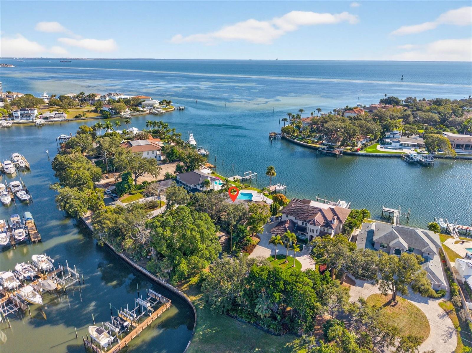 A once in a generation opportunity on one of the most exclusive drives in all of St Petersburg is being offered for the first time in over 42 years… welcome to 1323 Snell Harbor Drive NE.  Privately tucked away in the iconic waterfront neighborhood of Snell Isle, and home to only eight legacy residences, this secluded tree-lined cul-de-sac is surrounded on three sides by the sparkling open waters of Tampa Bay and the protected serenity of the coveted Snell Isle Harbor.  If you are looking for one of the most sought after locations in all of St. Pete to build new, or the chance to renovate and recreate into an icon, it just doesn’t get better than this.  Breathtaking views of BOTH open Tampa Bay AND Snell Isle Harbor greet you every day, and the sunrises at dawn are a sight to behold. A serious boater’s dream, this location is thought by many to be the most desired waterfront in all of Snell Isle. While providing immediate access to open Tampa Bay, it also offers the benefit of protected waters for most any type of watercraft and the perfect spot for wakeboarding, paddle boarding, jet skiing and more right in your own backyard. It also features a composite dock with 10,000 pound lift. All of this, just a few minutes to our vibrant and cultural downtown, via boat, bike or stroll.  The existing home, built in 1960 with a midcentury modern flair, offers an expansive 3,678 square feet of living space, all on one level. The incredible wide open floor plan provides a rare opportunity to be restored and reimagined into a contemporary vision of it’s modernist history. Striking waterfront views immediately greet you from the grand entry of the home. The living, dining, family and Florida rooms are each extremely generous in size and flow cohesively as they all overlook the sparkling 40,000 gallon pool, spa and waterfront. With 4 bedrooms and 4 ensuite bathrooms, there are private spaces for everyone. The wood burning fireplace, wrapped in a full wall of Norwegian Rose marble, is a stunning mid century feature. Recent upgrades include impact rated windows throughout the home (2017) tile roof (2017) and air conditioning (2020). If new construction is the dream, the oversized lot, at .36 acres, rests on approximately 89 ft. of water frontage and offers an unparalleled location for a buyer wishing to imagine and build a spectacular custom estate residence. A new survey is available for review. And so close and convenient to everything downtown St. Pete…from museums, cafes, fine dining, shopping, sporting events, outdoor concerts/events, and three airports including Tampa International.  The sky is the limit here to create a truly spectacular estate residence. The next chapter for this property is just waiting to be written.