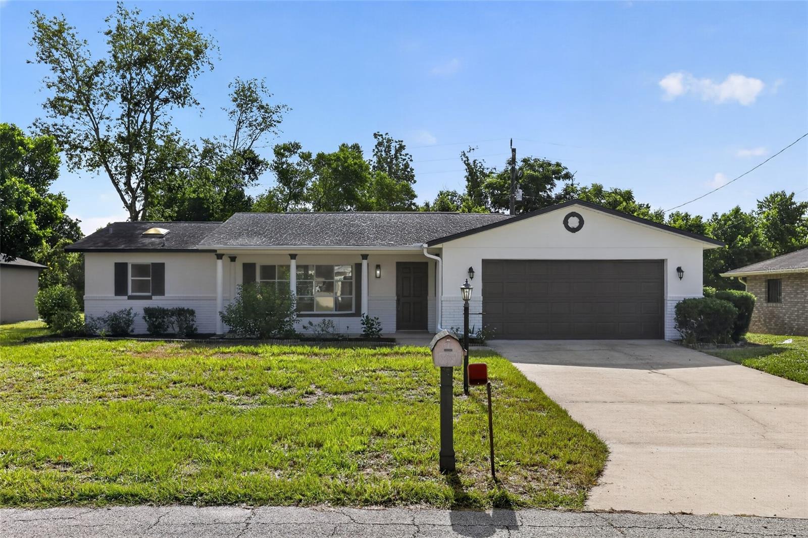 This thoughtfully refreshed 3 bedroom, 2 bath home in Deltona delivers meaningful updates throughout, offering genuine move-in ready appeal. The exterior features fresh white paint with iron ore accents and tidy landscaping, while the interior boasts a full repaint, new luxury vinyl plank flooring throughout, and new carpet in the bedrooms. The updated kitchen shines with refaced cabinetry, black hardware, new quartz countertops, a new stainless steel Whirlpool appliance package, and recessed LED lighting. Both bathrooms have been upgraded with new quartz vanities, undermount sinks, matte black fixtures, and updated finishes. Additional highlights include a refreshed enclosed rear porch with new glass panels, a freshly painted garage with a new water heater, and a new shingle roof with two replaced skylights. A well-maintained home with real, substantive updates ready for its next chapter.