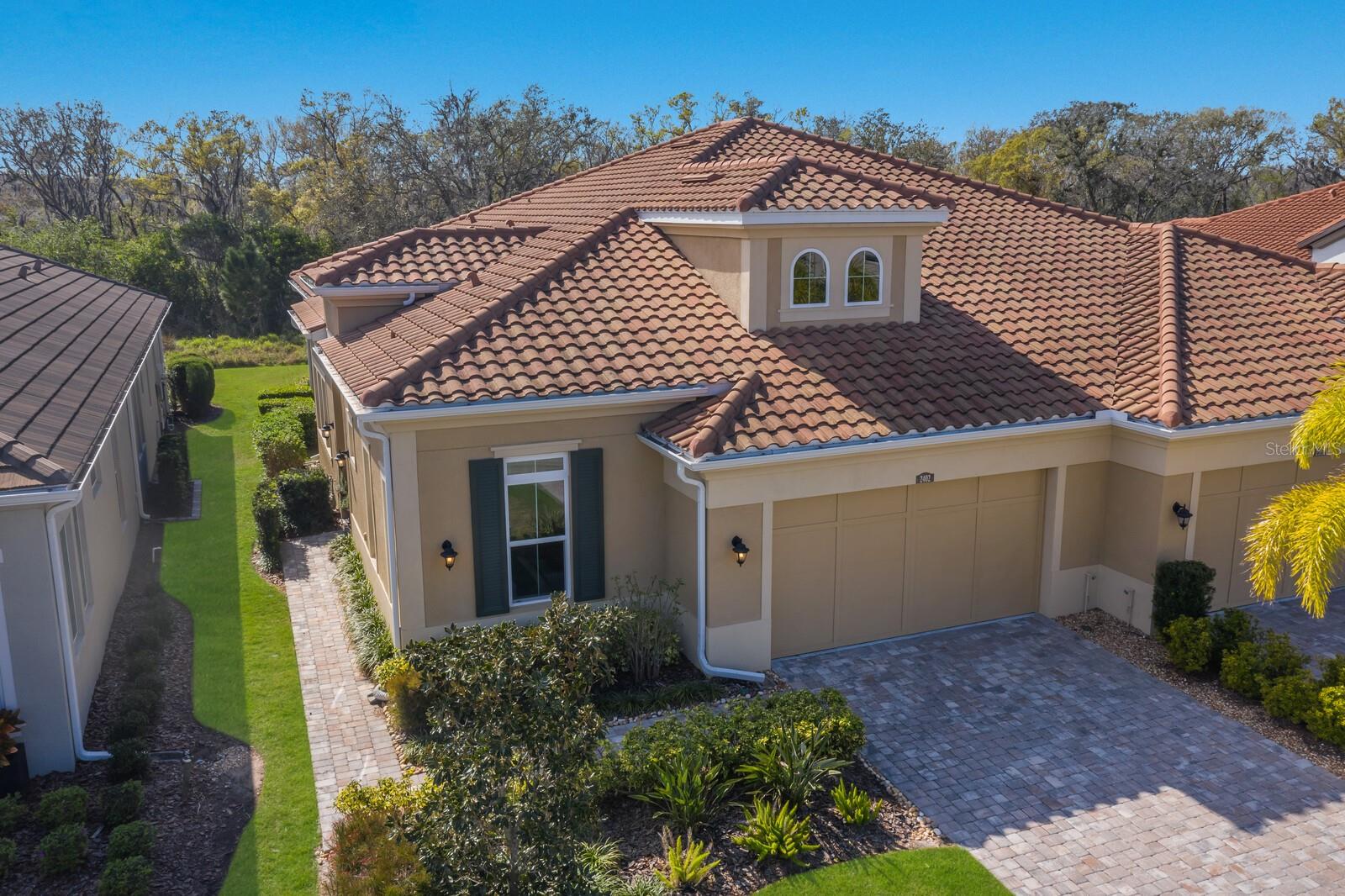 CALATLANTIC CUSTOM BUILT VILLA IN HIGHLY DESIRABLE ARBOR GRANDE! 2 BEDROOM, 2 BATH, PLUS OFFICE AND 2 CAR GARAGE! This custom built villa has many added architectural features, designer finishes, and soaring 12 FOOT CEILINGS. Additional high trayed ceilings can be found in the Primary bedroom, en suite bath, and all of the main living areas. Wall to wall glass sliders with additional transom windows above bring in lots of natural sunlight and enhances the open floorplan of this villa. Neutral colors throughout, as well as rich upgraded solid wood cabinets add to the fresh modern feel of this home. A beautiful gourmet kitchen with built in wall oven, gas cooktop and freestanding hood opens to the sunny dining area. Of course no home is complete without a spacious and private office-perfect for work from home! The many large windows, high ceilings, and 8 FOOT DOORS throughout show off just a few of the added features of this designer villa. Upon entering the leaded glass front door, you can see directly through to a park-like backyard with views of the preserve and pond. The screened lanai is perfect for sitting outdoors anytime of the day or night. Lanai is also pre-plumbed for natural gas, perfect for any outdoor cooking, and easy to add a summer kitchen. This home has generous storage space in the oversized laundry, coat closet, pantry and garage. Nicely appointed bathrooms are bright and contemporary. The walk-in pantry has solid wood shelves-floor to ceiling. Block construction along with a tile roof makes this villa both solid and quiet. The villas are nestled in a resort styled community, with a beautiful CLUBHOUSE, FITNESS CENTER, 2 HEATED POOLS, SPA, PICKLEBALL, BOCCE BALL, and a PRIVATE DOG PARK. This charming home sits directly across the street from all the PRIVATE Villa only amenities. This community has an onsite Manager, several social clubs and interest groups, as well as a very active social calendar of events and planned activities. Arbor Grande is situated next door to BOB GARDNER PARK with 3 resident only gate accesses. This attractive enclave of 122 homes is located in the #1 fastest growing community in the country-LAKEWOOD RANCH. Surrounded by excellent restaurants, shopping, LWR Main Street, and just a 45 minute drive to our world famous beaches makes this an ideal area for your new home. You can enjoy all that resort styled living has to offer with no worry-this community is MAINTENANCE FREE too! This home has been lovingly kept and maintained. Easy to view and move-in ready! See you very soon!