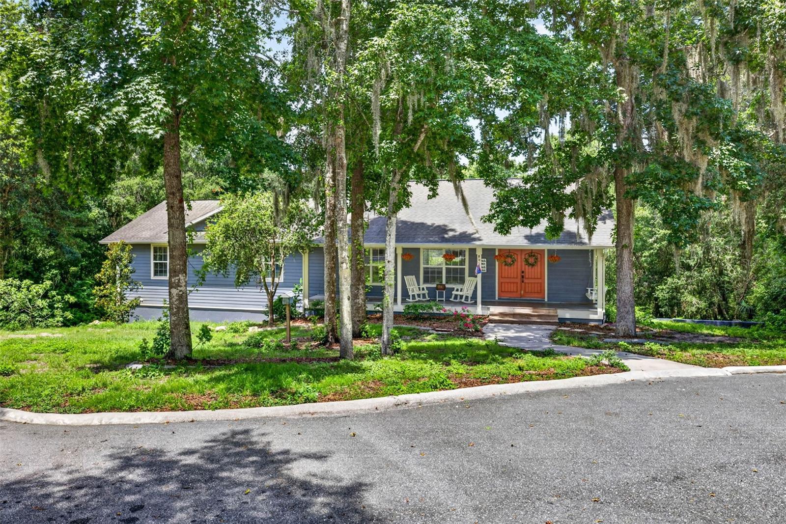 This beautiful custom-built home sits on 3.4 private acres with a scenic pond, a huge pole barn, and so many thoughtful details throughout. Built in 2010, this property delivers the space, comfort, and peaceful country setting that can be hard to find. This is the perfect homestead setup, with garden beds ready for your next planting, established fruit trees, room for livestock, and even a spot for chickens. Whether you dream of fresh produce, backyard eggs, animals, hobbies, multi-generational living, or just more breathing room, this property gives you the space to make it happen. Major updates add even more value, including a previously replaced drainfield and a newer HVAC system. From the moment you pull into the circular driveway, the inviting front porch and timeless curb appeal make a great first impression. The exterior features durable James Hardie siding with decorative shake accents, giving the home both charm and quality. Inside, the open floor plan feels warm and welcoming with soaring ceilings, decorative wood beams, Golden Teak hardwood flooring, upgraded lighting, and lots of natural light. The living room is anchored by a beautiful floor-to-ceiling stone fireplace with a custom mantel and granite hearth, making it the perfect gathering space. The kitchen is spacious, functional, and full of character with custom 42-inch hickory cabinets, granite countertops, stainless steel LG appliances, a large breakfast bar with decorative wainscoting, and oversized tile flooring. It opens nicely to the main living areas, making everyday living and entertaining easy. The floor plan gives everyone plenty of privacy. The primary suite is tucked away and features a custom wood tray ceiling, a large walk-in closet with built-in storage, and a beautiful en-suite bath with dual vanities, quartzite countertops, a garden tub with custom brick detail, and a walk-in shower with river rock flooring and glass enclosure. On the opposite side of the home, there is a second primary suite or in-law suite with its own walk-in closet and private bathroom. This is such a great setup for guests, extended family, or multi-generational living, giving everyone comfort, privacy, and room to spread out. Two additional guest bedrooms include custom closet systems and share an updated bathroom with quartzite countertops and designer tile finishes.
The home also offers a fifth bedroom, a laundry room, great storage, and an oversized bonus room with a walk-in closet and French doors leading outside. This space could easily be used as a sixth bedroom, media room, office, gym, playroom, or whatever fits your needs.
Outside is where this property really shines. Enjoy peaceful views of the woods and pond from the covered outdoor living areas, with plenty of room to relax, entertain, garden, and enjoy the Florida lifestyle. One of the biggest highlights is the massive 48' x 30' pole barn with an attached workshop, built-in shelving, electrical service, and an additional parking pad. Bring the boats, RVs, recreational vehicles, equipment, livestock supplies, or hobbies because there is room for it all. With private acreage, flexible living spaces, quality finishes, homestead potential, multi-generational living options, and incredible outdoor amenities, this one-of-a-kind property gives you room to spread out, slow down, and enjoy the best of country living.