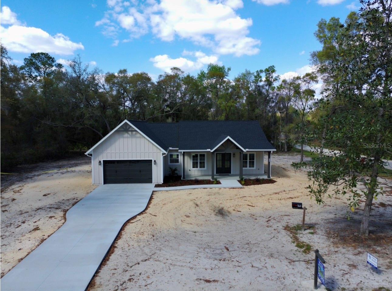 Experience the perfect blend of luxury craftsmanship and laid-back country living in this exceptional custom-built residence in Chiefland. If you’ve been dreaming of a high-end custom home without the time, stress, and uncertainty of building—this is your opportunity.
Situated on a spacious 1-acre corner lot, on a paved road, this stunning 3-bedroom, 2.5-bath new construction home is a true showstopper, thoughtfully designed with impeccable attention to detail at every turn. From the moment you arrive, the long concrete driveway, striking curb appeal, oversized columns, and charming farmhouse aesthetic set the tone for what awaits inside.
Step through grand double entry doors into a beautifully appointed interior featuring soaring 10-foot ceilings, 8-foot doors throughout, and an open-concept layout designed for both everyday living and entertaining. The living room is anchored by a custom built-in electric fireplace, complemented by designer cabinetry and shelving—creating a warm yet elevated focal point.
Luxury vinyl plank flooring flows seamlessly throughout the home, enhancing both style and durability. The chef’s kitchen is a true centerpiece, boasting custom cabinetry, a massive quartz island with convenient pop-up outlets, a farmhouse sink positioned beneath a picturesque window, stainless steel appliances, and a stylish backsplash. Just beyond, the dream pantry offers abundant shelving, an additional farmhouse sink, and even a charming chalkboard wall—perfect for organizing your daily life in style.
Attention to detail continues with upgraded lighting, custom wall features, and a thoughtfully designed drop zone. A well-placed half bath provides convenience for guests, while the spacious laundry room is outfitted with extensive cabinetry for optimal functionality.
The owner’s retreat is a private sanctuary, featuring a generously sized bedroom, an oversized walk-in closet, and a spa-inspired bathroom complete with a long double vanity with tower storage, an expansive walk-in shower, and a private water closet.
Two additional bedrooms are well-sized and share a beautifully finished full bath with a tiled surround and custom cabinetry touches, maintaining the home’s cohesive, high-end feel.
Step outside through French doors to a large covered back porch—ideal for relaxing and taking in the peaceful surroundings of your expansive backyard.
Enjoy the best of both worlds with a serene country setting just minutes from everyday conveniences. Located within 10 minutes of shopping, dining, and medical facilities, and close to the natural beauty of the Suwannee River and area springs, you’re also only about 35 minutes from the coastal charm of Cedar Key and the Gulf of Mexico.
This is more than just a home—it’s a lifestyle upgrade. A must-see property where quality, comfort, and thoughtful design come together seamlessly.