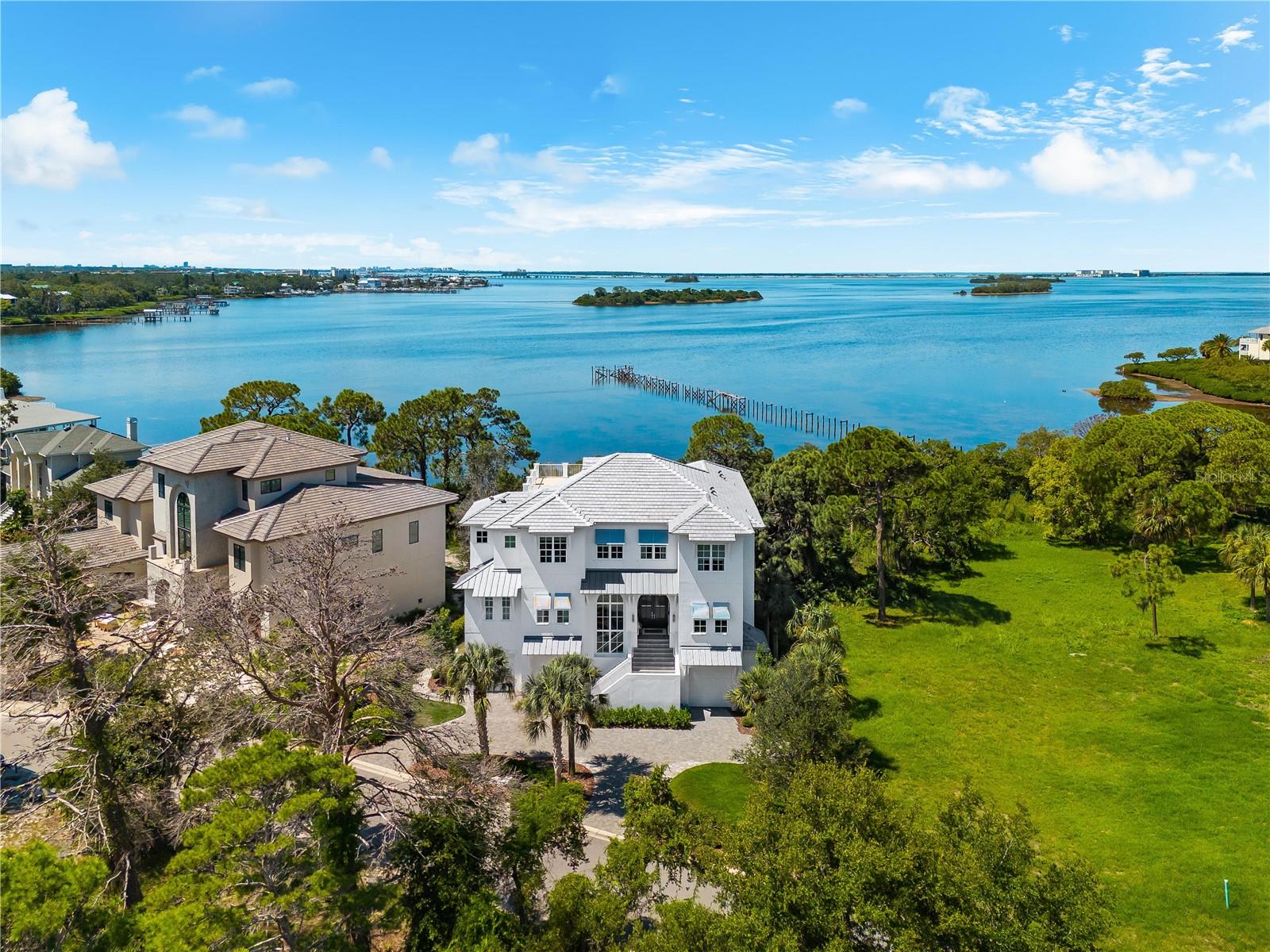 Boldly architectural, exquisitely styled, and rich in provenance, 885 Seaview Drive is a one-of-a-kind waterfront estate where editorial design meets masterful construction. Perched on 45 feet of bayou frontage in Crystal Beach’s coveted Turtle Beach enclave, this newly remodeled 7-bedroom, 7-bath residence is the embodiment of coastal sophistication—designed for those who demand beauty, quality, and quiet exclusivity. From the moment you enter, the tone is unmistakable: this is a designer’s home. A crystal chandelier floats overhead with an automated lift system. Soaring 22-foot ceilings and floor-to-ceiling glass create a luminous great room with panoramic views of Sutherland Bayou. A dramatic stacked-stone ethanol fireplace anchors the space, flanked by 10-foot sliding glass doors that dissolve the boundaries between indoors and out.

Meticulous 2025 upgrades elevate every inch of this home. A brand-new roof and expansive fourth-floor sundeck by Arry’s Roofing, fresh exterior and interior paint, custom light fixtures, and professionally finished garage and gym flooring by Haven Floors—used in luxury fitness studios across the country—set a new benchmark in form and function. The ground-level garage is fully climate-controlled, featuring Mitsubishi split systems and epoxy flooring, transforming it into a versatile flex space for wellness, recreation, or creative pursuits.

The chef’s kitchen is a functional work of art—anchored by a 6-burner Wolf gas range, Sub-Zero refrigeration, quartz countertops, a large prep island, and hand-selected finishes that balance warmth with precision. Entertain effortlessly in the formal dining room, flow into the open-concept patio, or retreat to the private media lounge and executive office.

A residential elevator offers seamless access to all levels, including the serene owner’s suite with water views, a spa-inspired bath, dual vanities, an oversized walk-in shower with body jets and rain heads, and a 14’ x 11’ custom closet space awaiting your vision. Each additional bedroom features a private en-suite bath and a bespoke walk-in closet handcrafted by a master cabinetmaker from the East Coast.

Outside, the experience is resort-level. An 18x30 salt-chlorine water pool with oversized sun shelf glimmers beneath the Florida sky. Surrounded by more than 1,100 square feet of travertine tile, this outdoor haven includes a heater, chiller, and a programmable LED light show foundation—perfect for both quiet evenings and grand entertaining. Newly installed aluminum fencing provides discreet security without interrupting the water views.

But this home is more than beautiful. It is recognized. Every bedroom has been featured in Pottery Barn campaigns. The entire residence has served as the backdrop for global brands including Elle Decor, Pottery Barn Kids & Teen, HomeGoods, Target, Wayfair, and Better Homes & Gardens. The designer herself has been showcased on HGTV, Good Morning America, Southern Living, Seventeen, Real Simple, and People Magazine.

Located in one of the Gulf Coast’s most charming and laid-back communities, this home offers direct access to the Pinellas Trail, sunsets at Live Oak Park, golf-cart-friendly streets, and top-tier schools including Palm Harbor University High. This is not just a home—it’s a legacy property, a statement, and a story waiting to unfold.